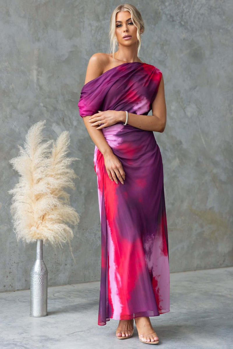 Jules Maxi Dress featuring an asymmetric neckline and side ruching, in a vibrant pink and purple tie-dye design.