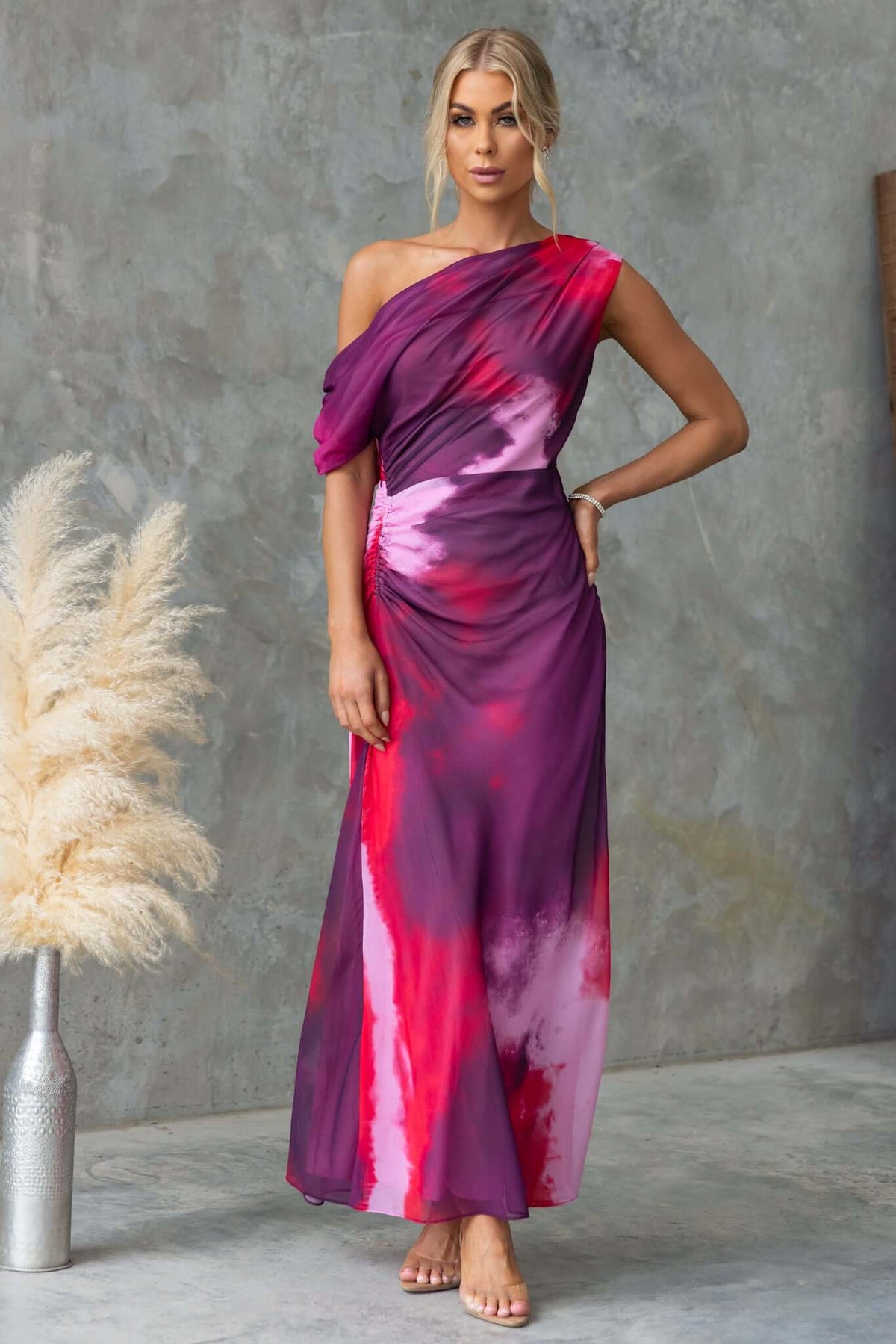 Jules Maxi Dress featuring asymmetric neckline and side ruching in vibrant pink and purple hues, perfect for elegant occasions.