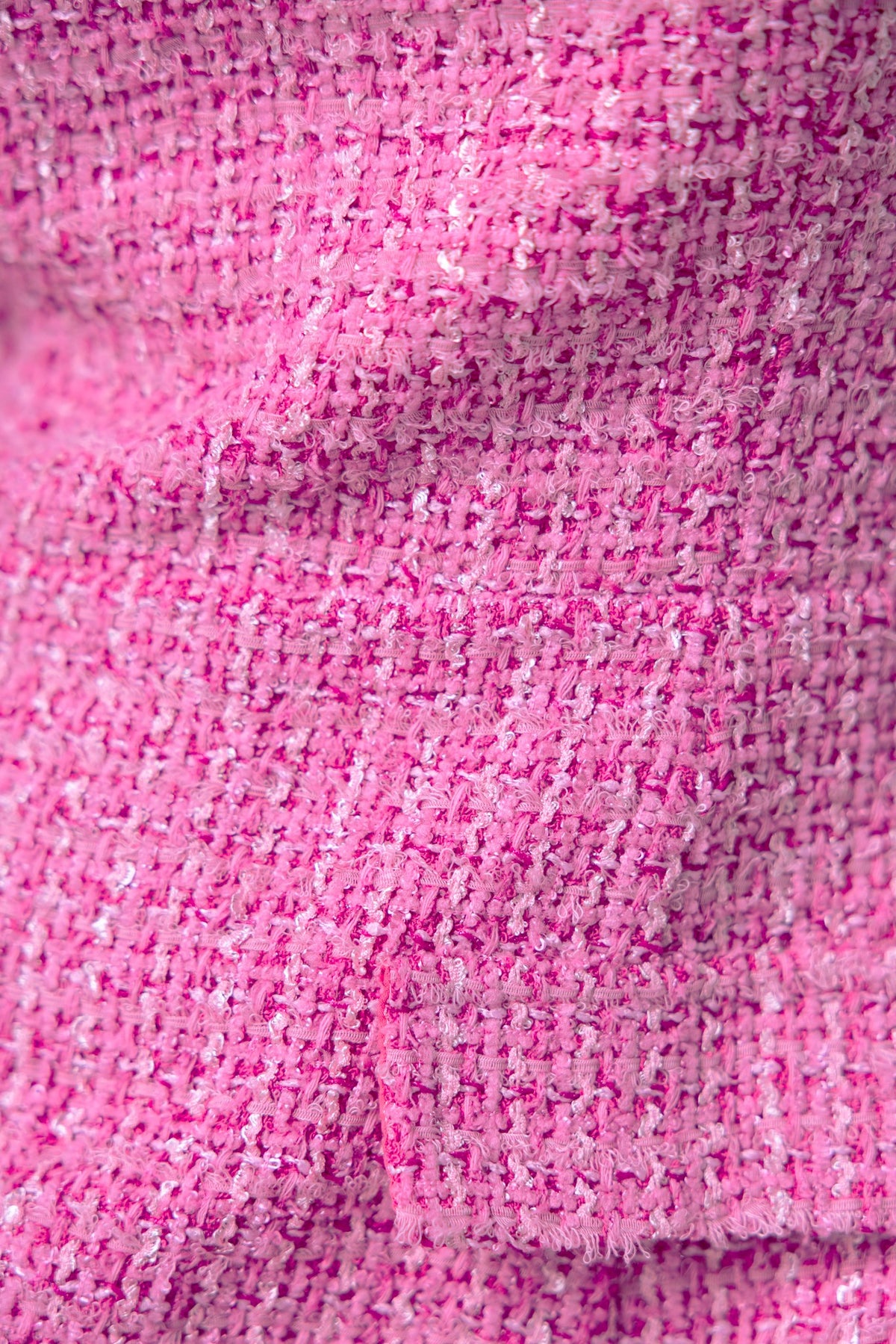 Close-up of pink chenille fabric texture, showcasing the soft and vibrant weave for the Junnie Dress.