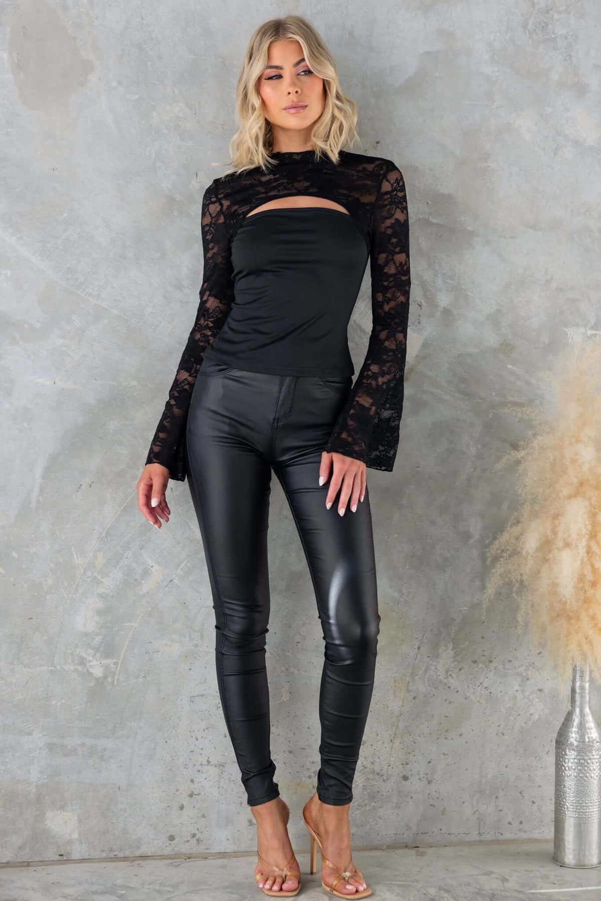 Model wearing Kaiya Top with mock neckline and lace panel, paired with black leggings in a chic setting.
