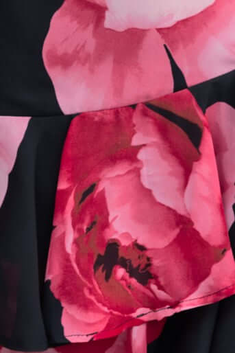 Close-up of floral print on Kameryn Maxi Dress, featuring vibrant pink hues on chiffon fabric.