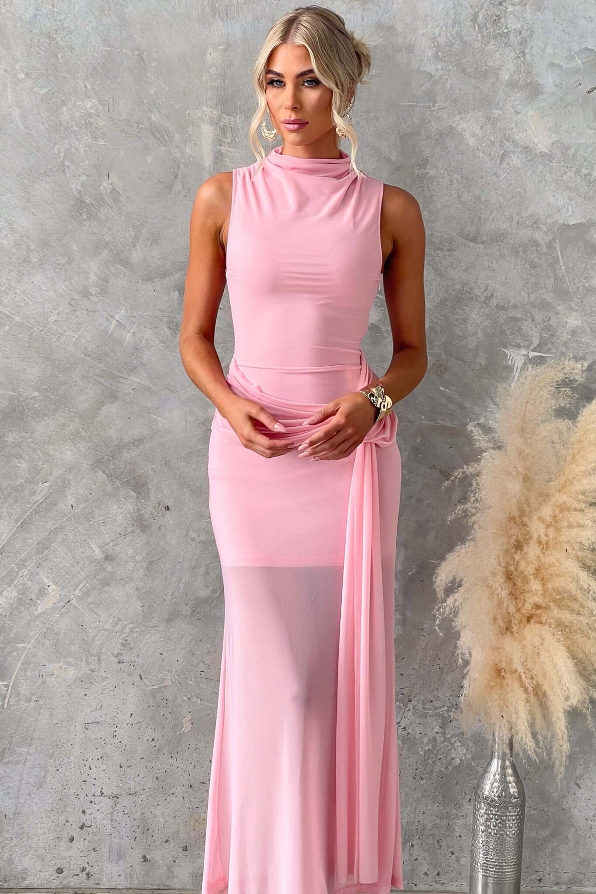 Model wearing Karter Maxi Dress in pink with high neckline and draping waist detail, showcasing stretch and elegance.