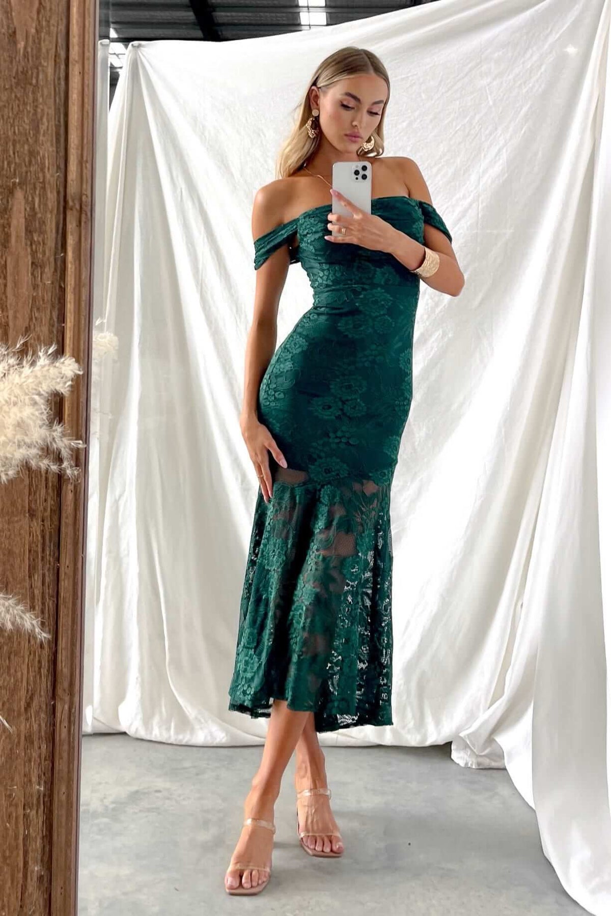 Model wearing Kearney Midi Dress in dark green lace, off-shoulder style with a fitted silhouette and knee-length skirt.