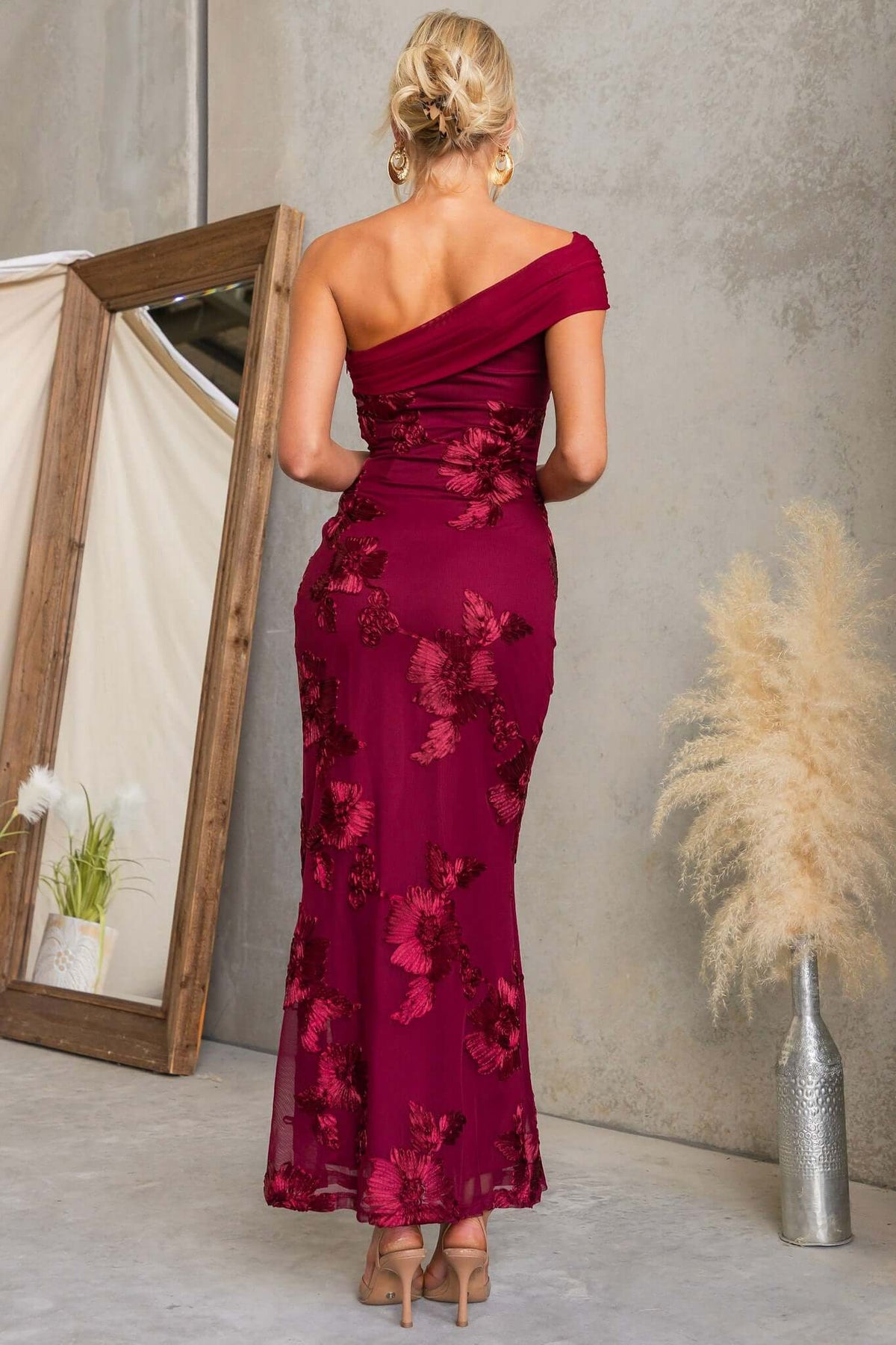 Back view of a woman wearing the Korren Maxi Dress with embossed floral design in burgundy.