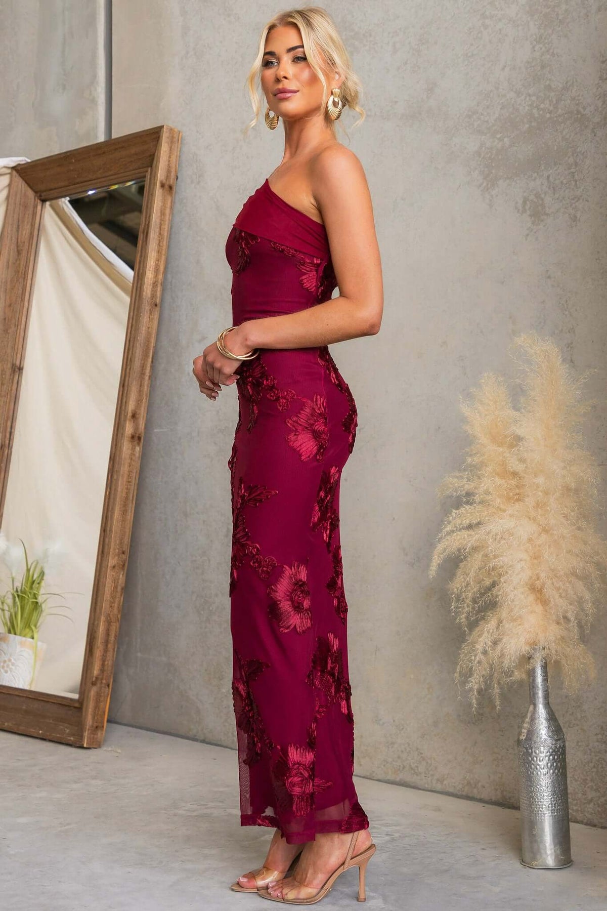 Model showcasing the Korren Maxi Dress with one-shoulder neckline and floral embroidery.