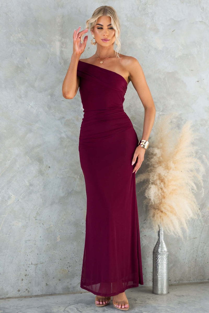 Korren Maxi Dress in burgundy, featuring a one-shoulder design, sleek fit, and made from stretchy mesh material.