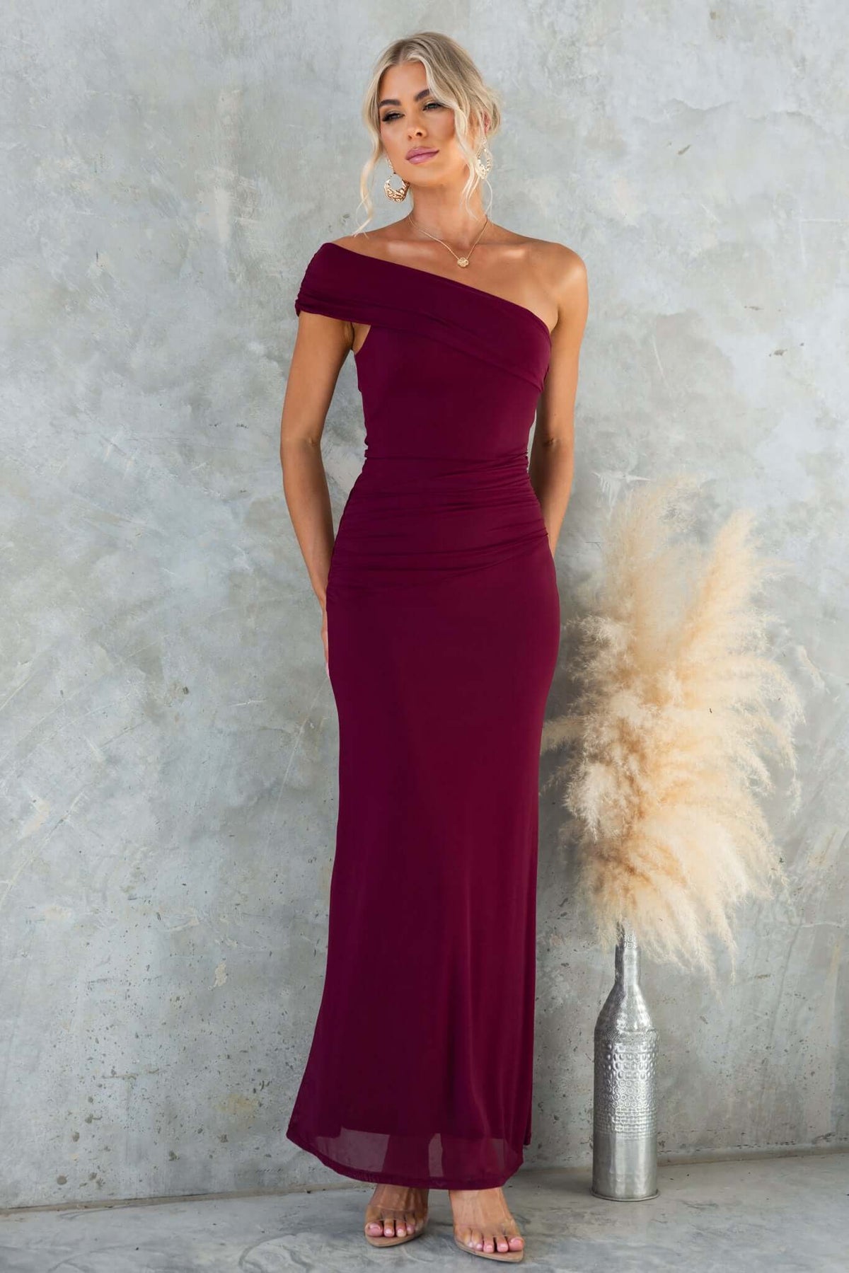 Korren Maxi Dress in burgundy, featuring a one-shoulder neckline and a fitted design, ideal for elegant occasions.