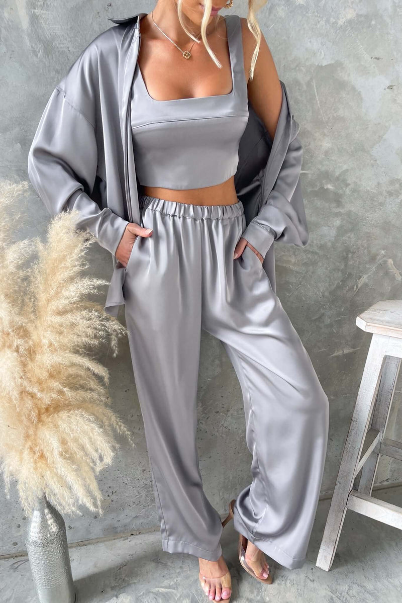 Model wearing Kortez Pants, mid-high waist satin pants with pockets, elastic waistband, styled with a matching top.