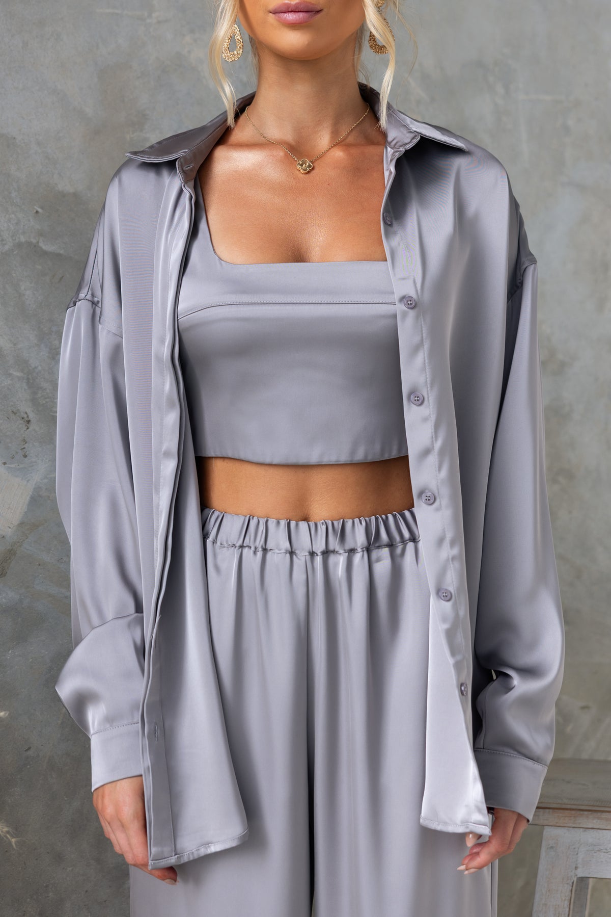 Model wearing Kortez Shirt in satin material, featuring a button-up front and collar, styled with matching bottoms.