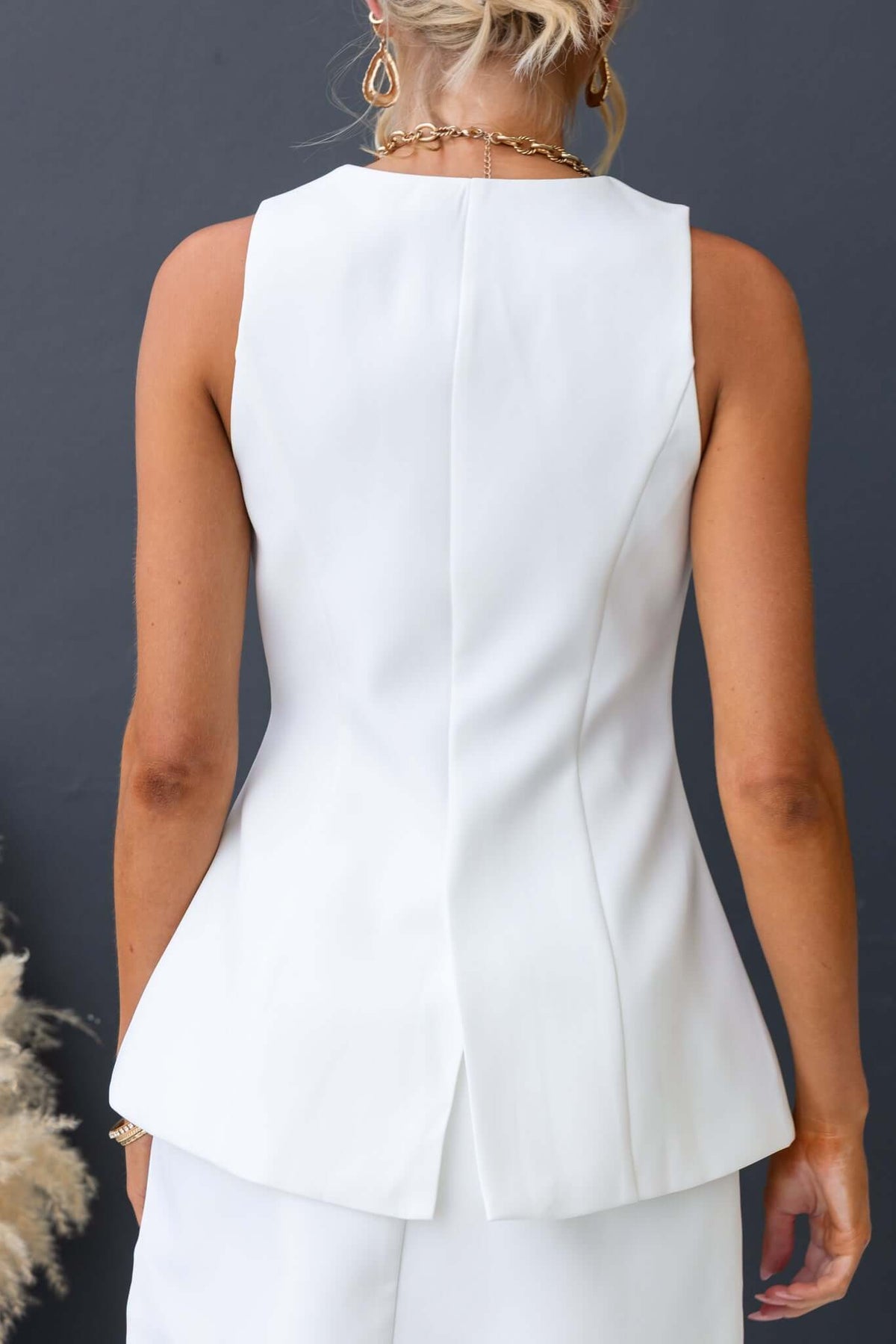 Back view of Laredo Top featuring a vest style, V-neckline, and stylish button-up front in white polyester.