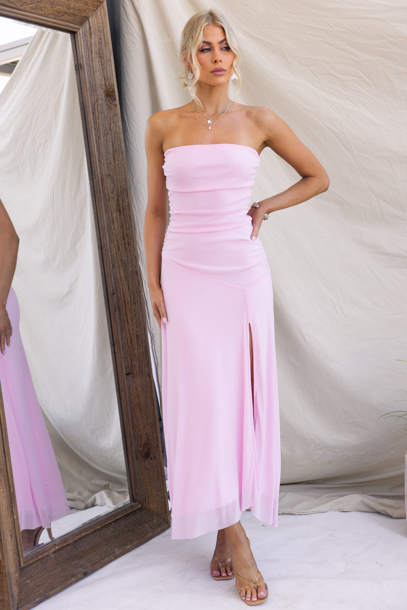 Legrand Maxi Dress in pink, strapless with front split, showcasing a model standing in front of a mirror.