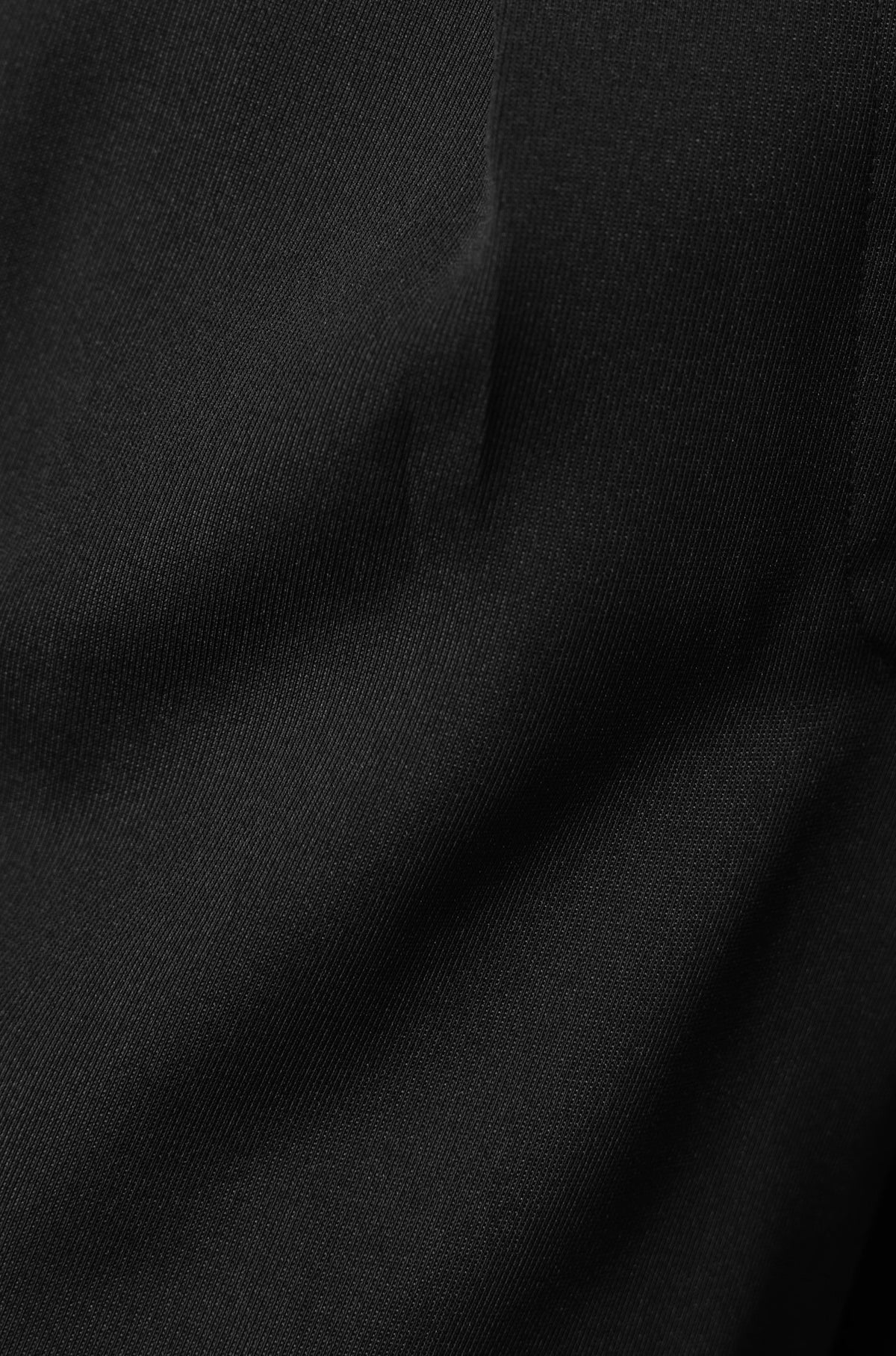 Close-up of Lesky Pants fabric showing smooth black texture and non-stretch material.