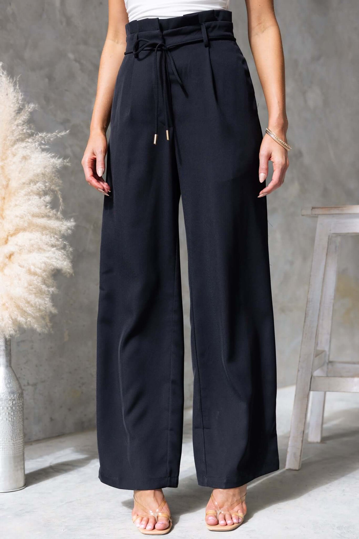 Lesky Pants with paperbag waist, removable tie, and pockets, modeled by a woman against a neutral background.