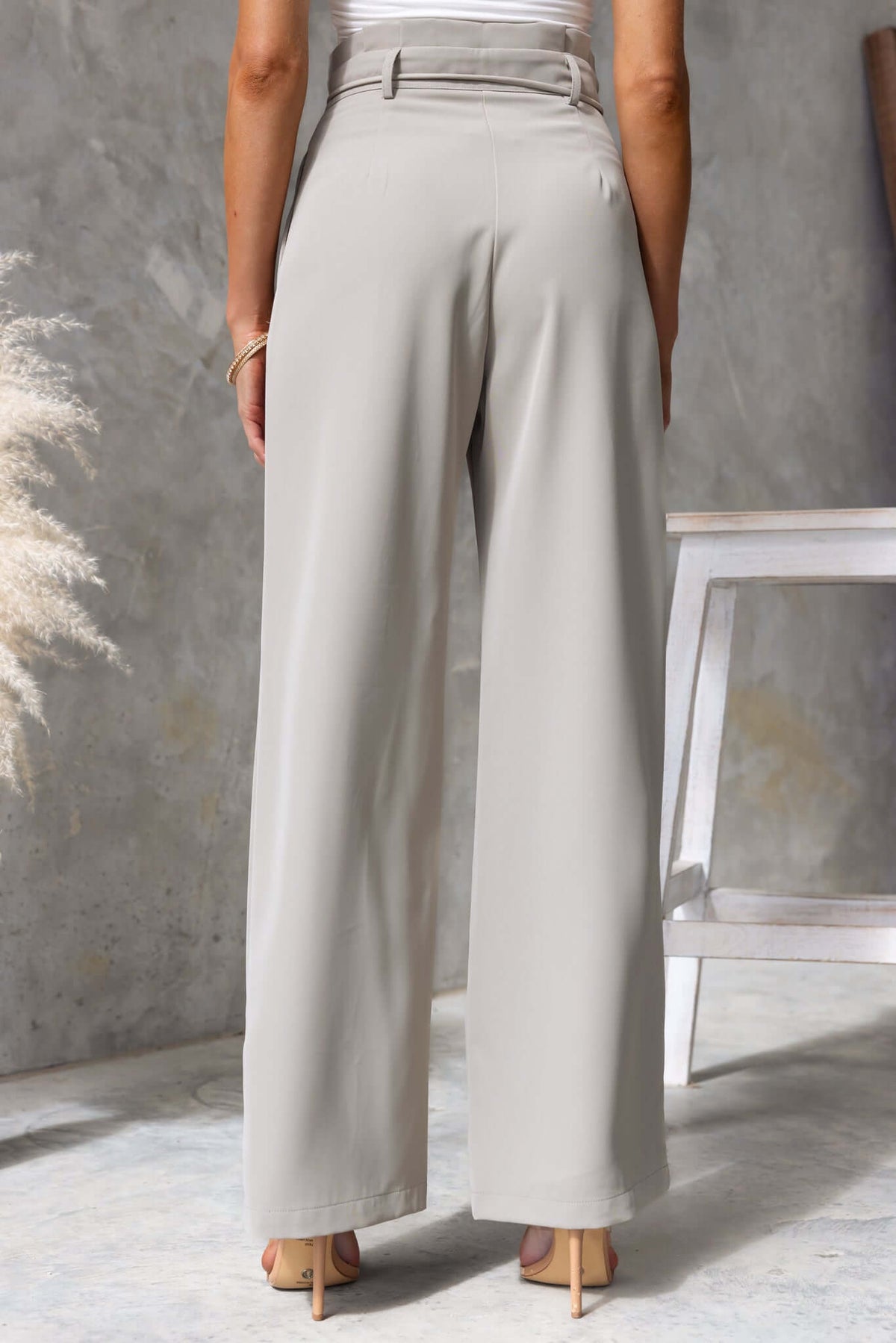 Lesky Pants in soft gray with paperbag waist and removable fabric tie, showcasing mid-high fit and wide-leg style.