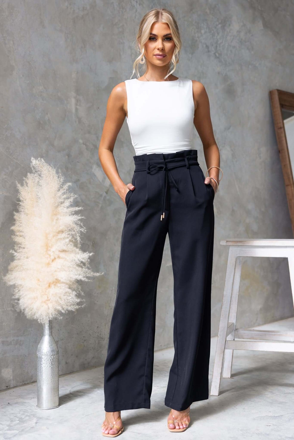 Lesky Pants with paperbag waist in black, featuring removable tie and pockets, modeled with a white top.