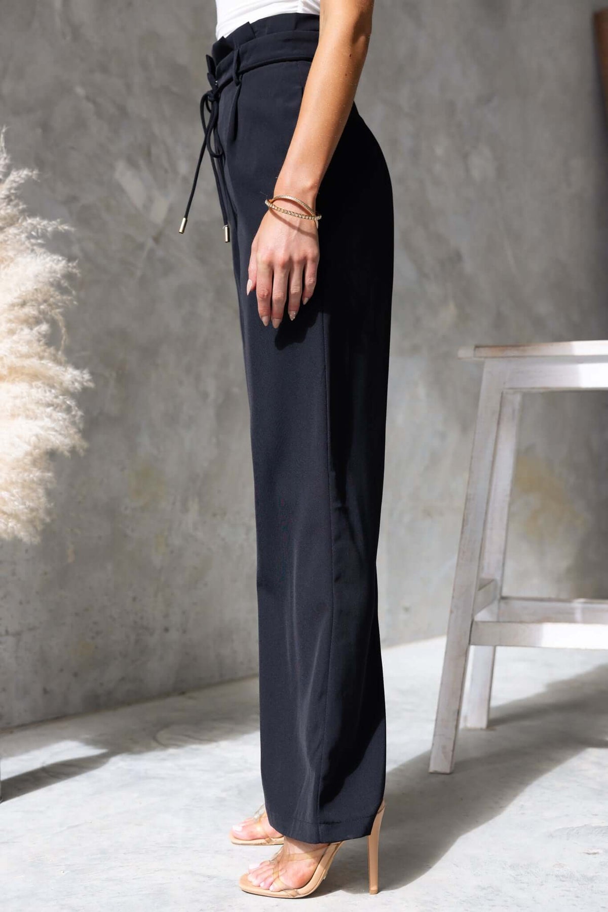 Lesky Pants featuring a paperbag waist design, removable fabric tie, and elegant fit shown in black.