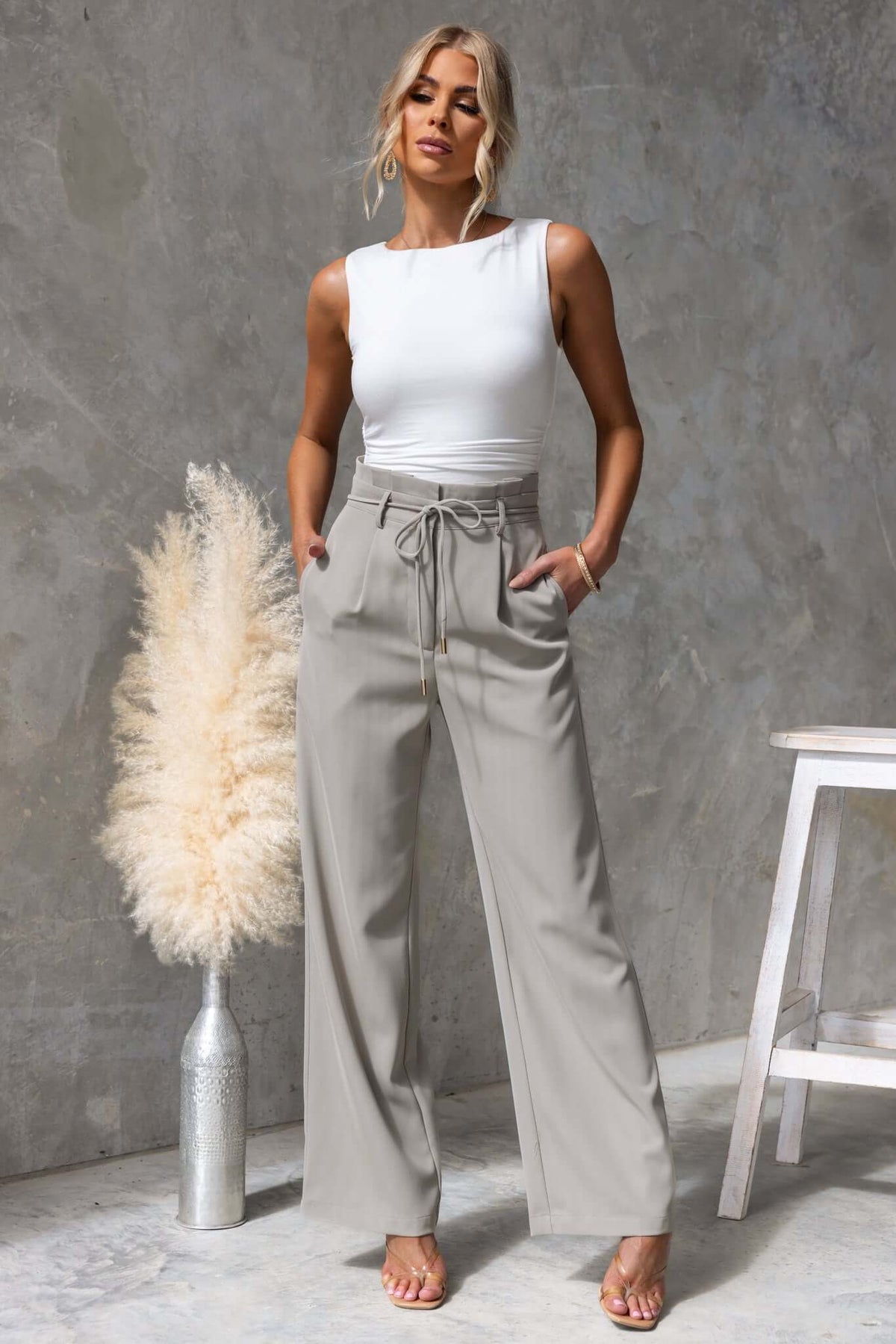 Lesky pants featuring a paperbag waist, mid-high fit, removable tie, and pockets, styled with a fitted top.