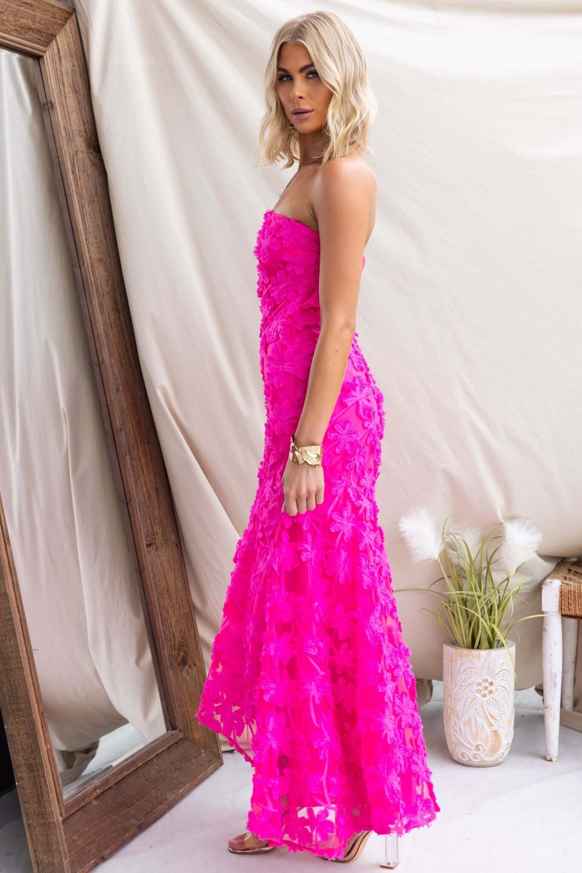 Lilium Maxi Dress in vibrant pink, strapless with embroidered material and invisible zip, showcased against a light backdrop.