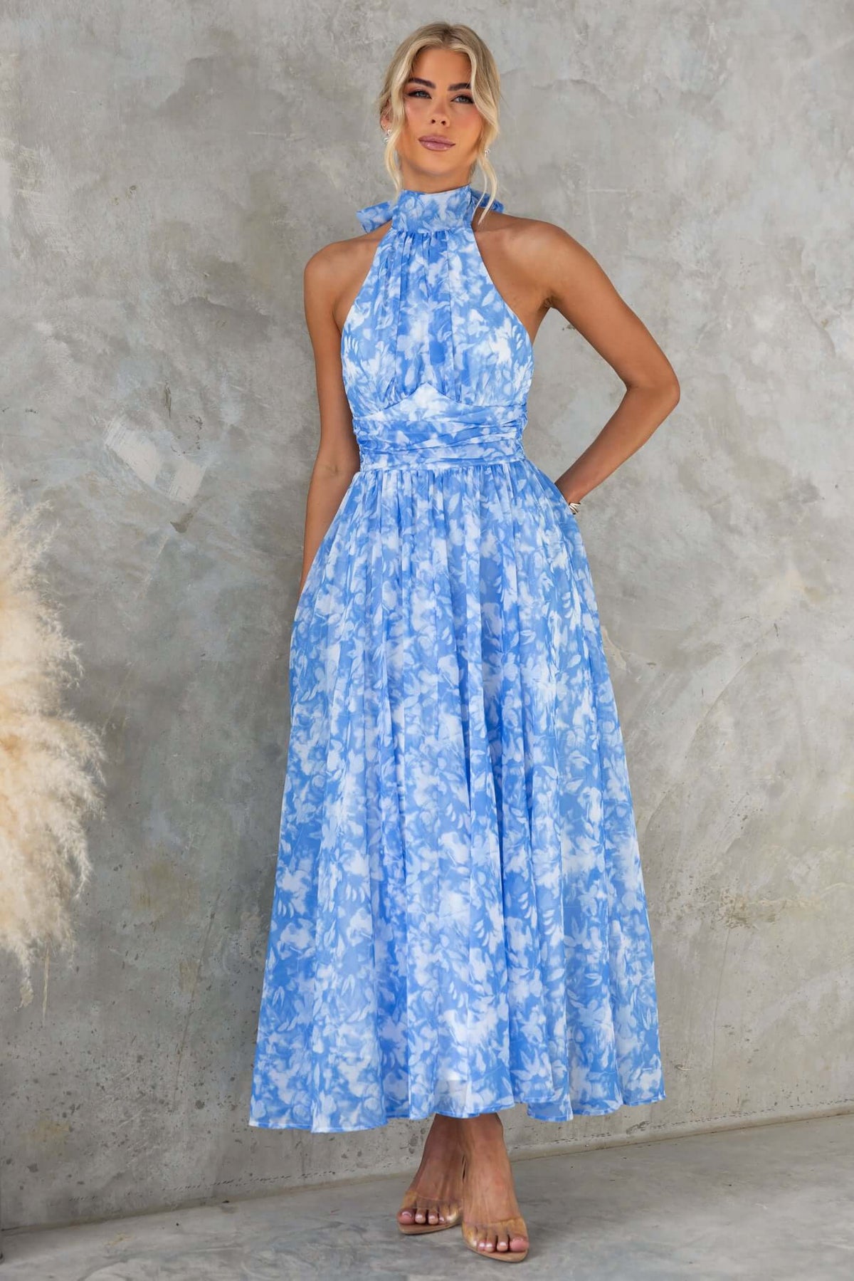 Little Things Maxi Dress in blue floral print, featuring a high tie neckline and a flowing silhouette.