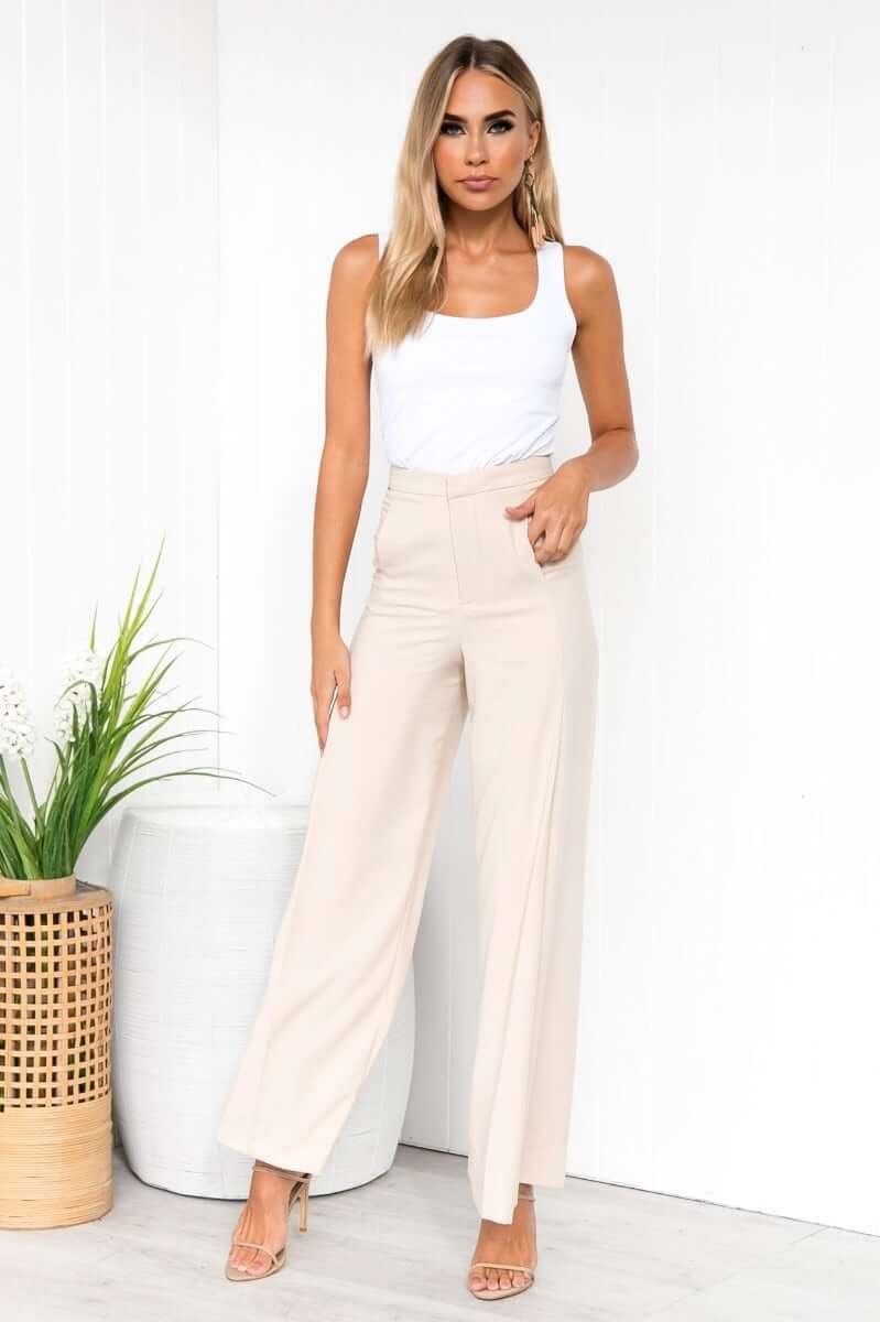 Model wearing Layla Top in ice white with high-waisted beige pants, showcasing a chic and stylish look for casual occasions.