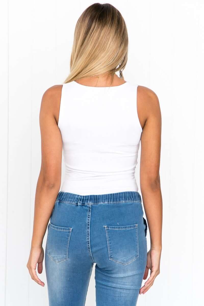 Back view of Layla Top by Amaroso the Label, ice white basic tank top paired with blue denim jeans.