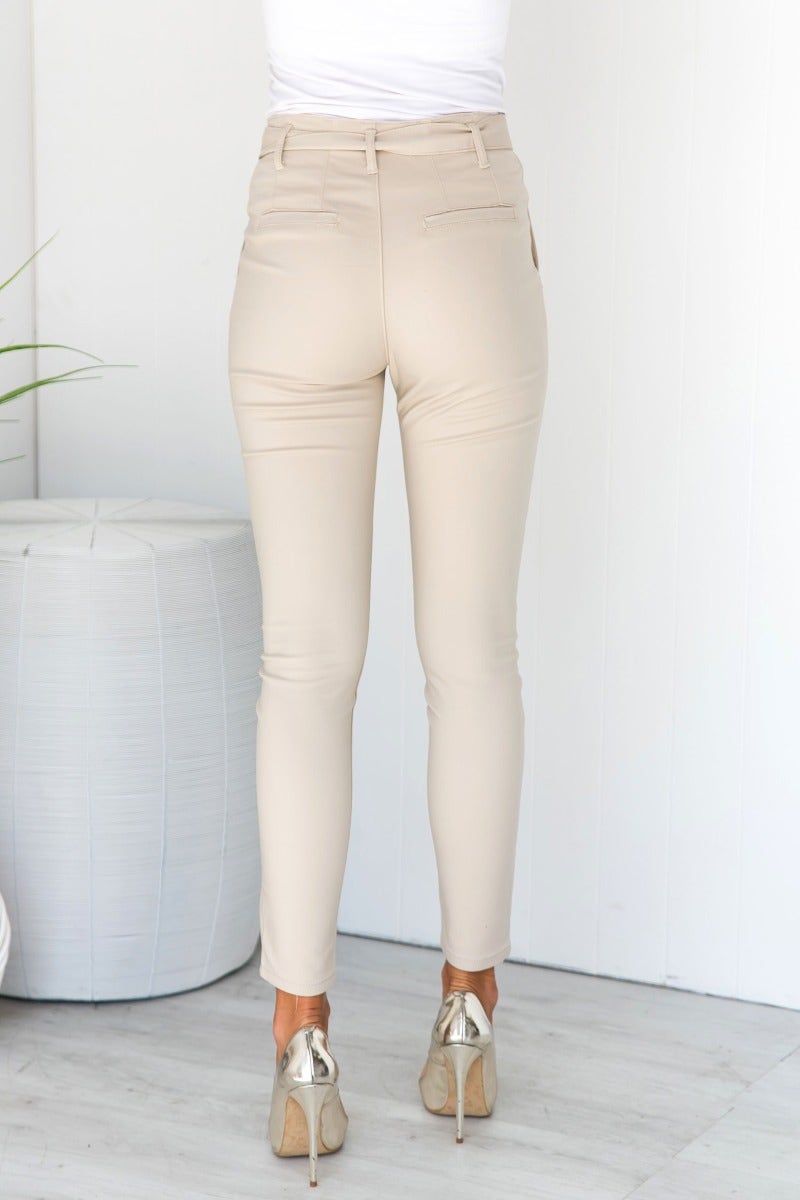 Back view of Mrs Smith Pants in beige, featuring a high waist fit, removable fabric belt, and firm stretch material.