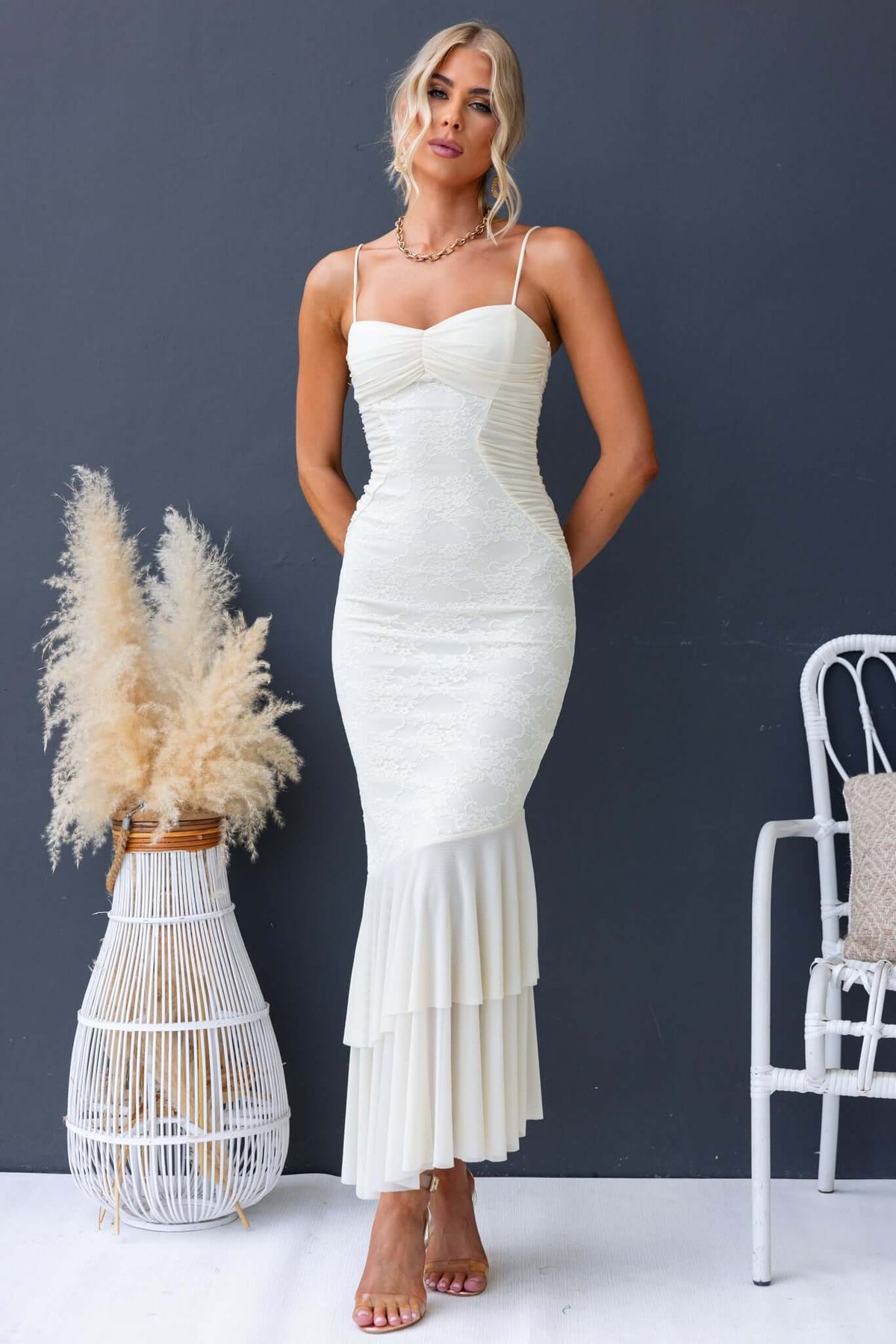 Elegant Marilou Maxi Dress featuring adjustable straps, lace detailing, and a flared hem in a stylish outdoor setting.