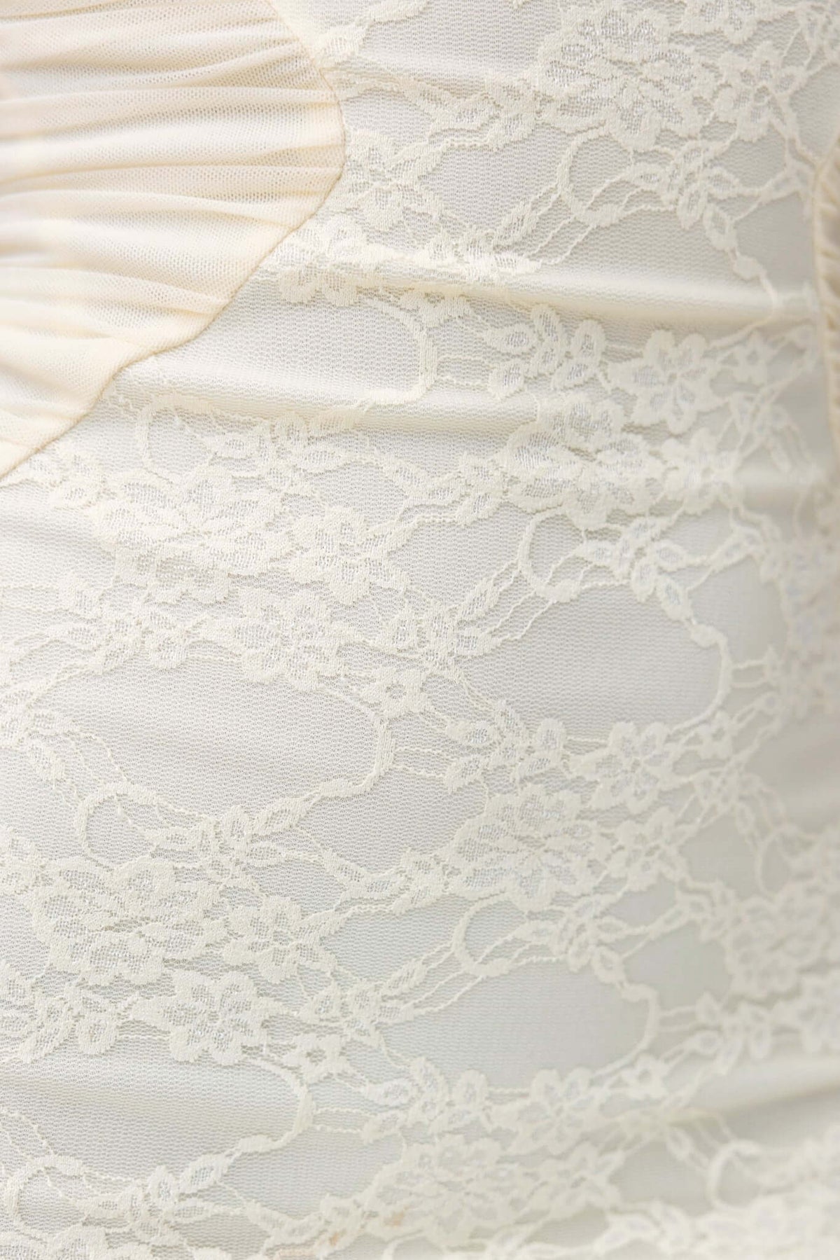 Close-up of lace detailing on Marilou Maxi Dress in soft ivory color, featuring intricate patterns and texture.