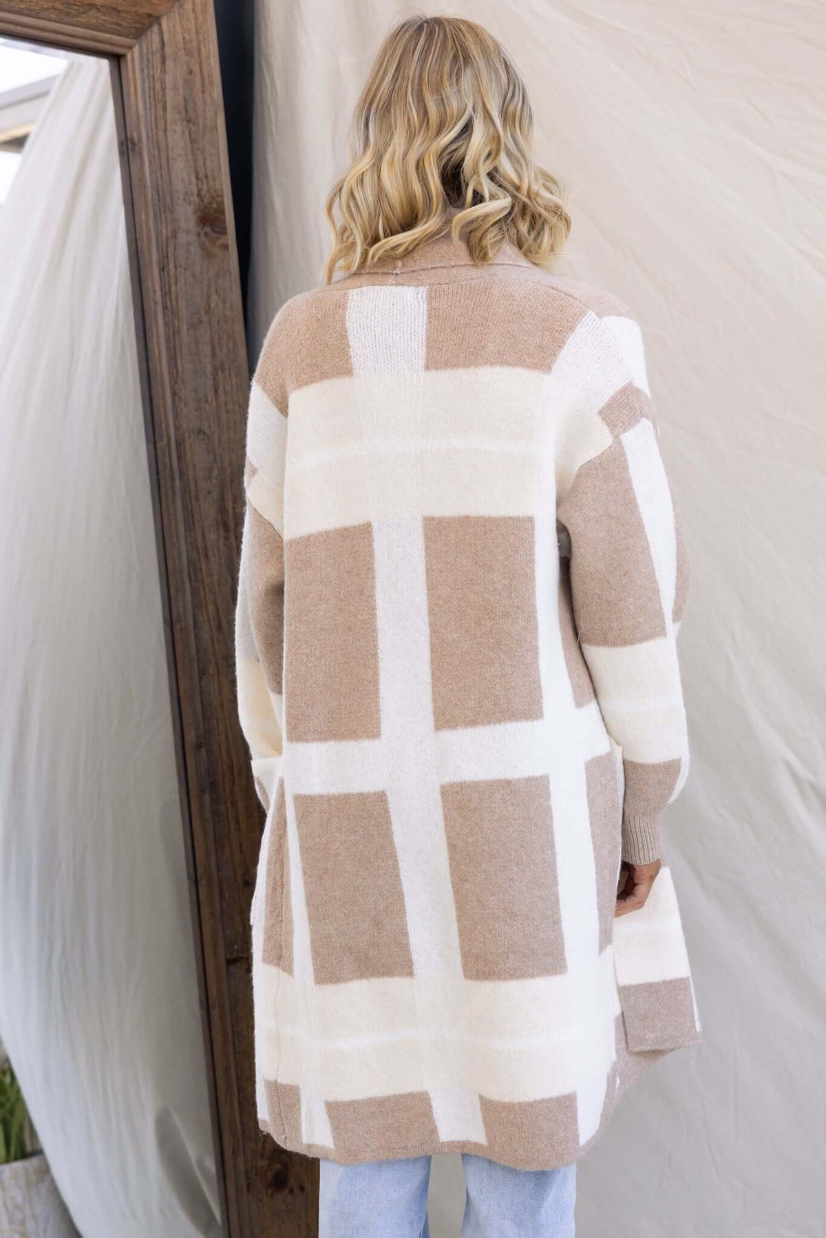 Mason Cardigan in beige and white check, featuring a relaxed fit, collar, and pockets, made of stretchy knit material.