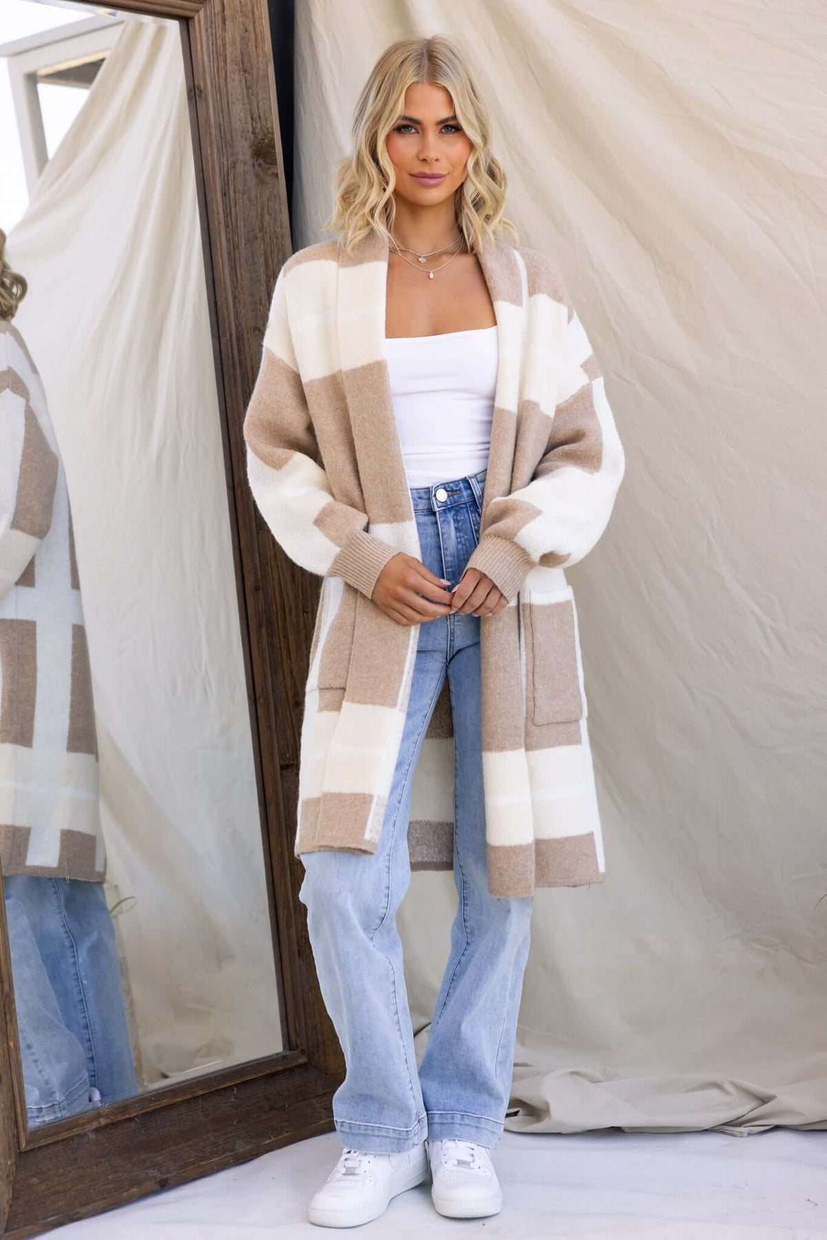 Model wearing a relaxed fit Mason Cardigan in knit material, featuring a collar and pockets, styled with jeans.