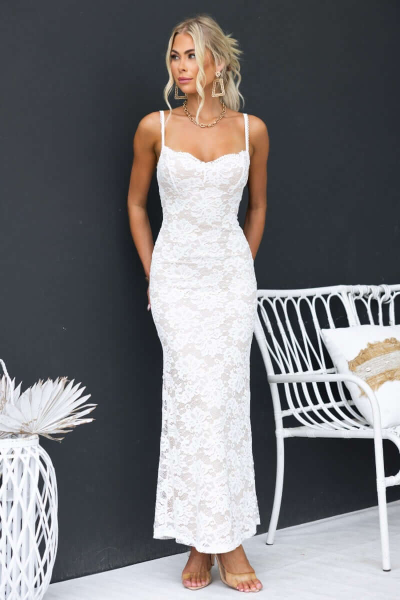 Elegant lace maxi dress with adjustable straps, showcased by a model against a dark background.