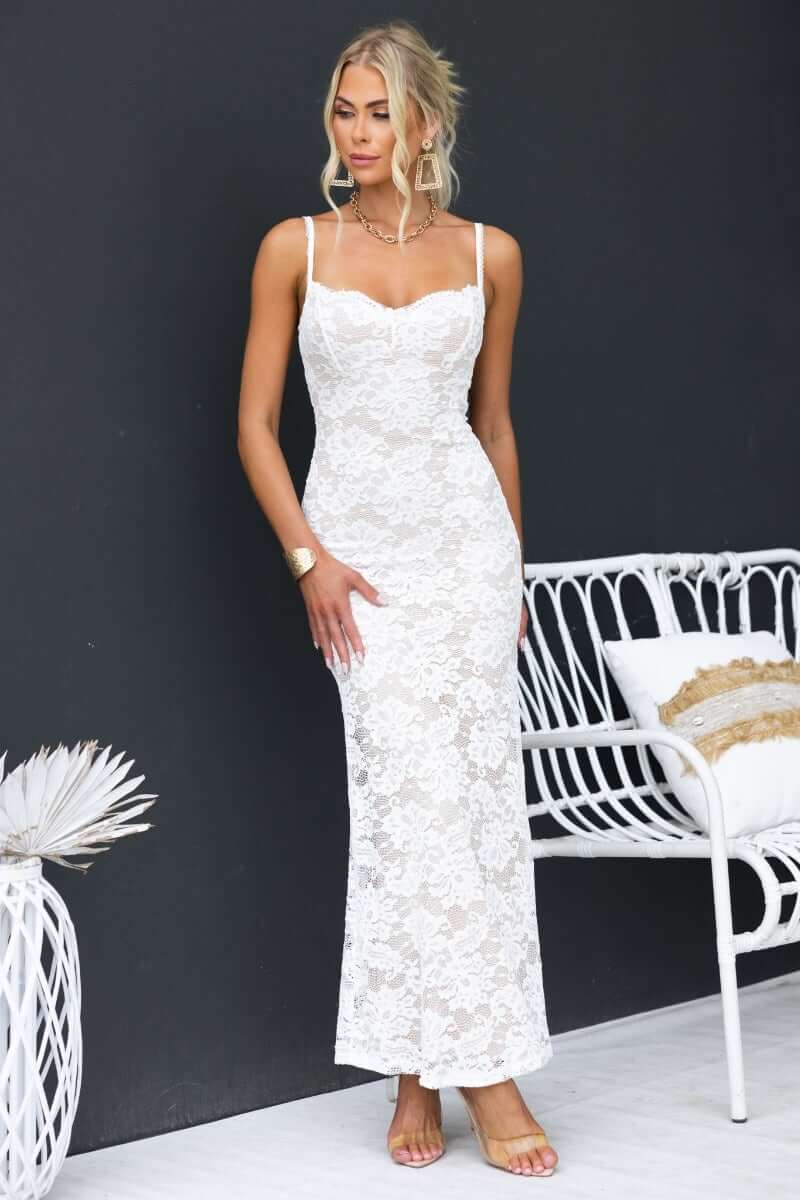 Model wearing a lace Mesmerise Maxi Dress with adjustable straps, styled elegantly in front of a dark backdrop.