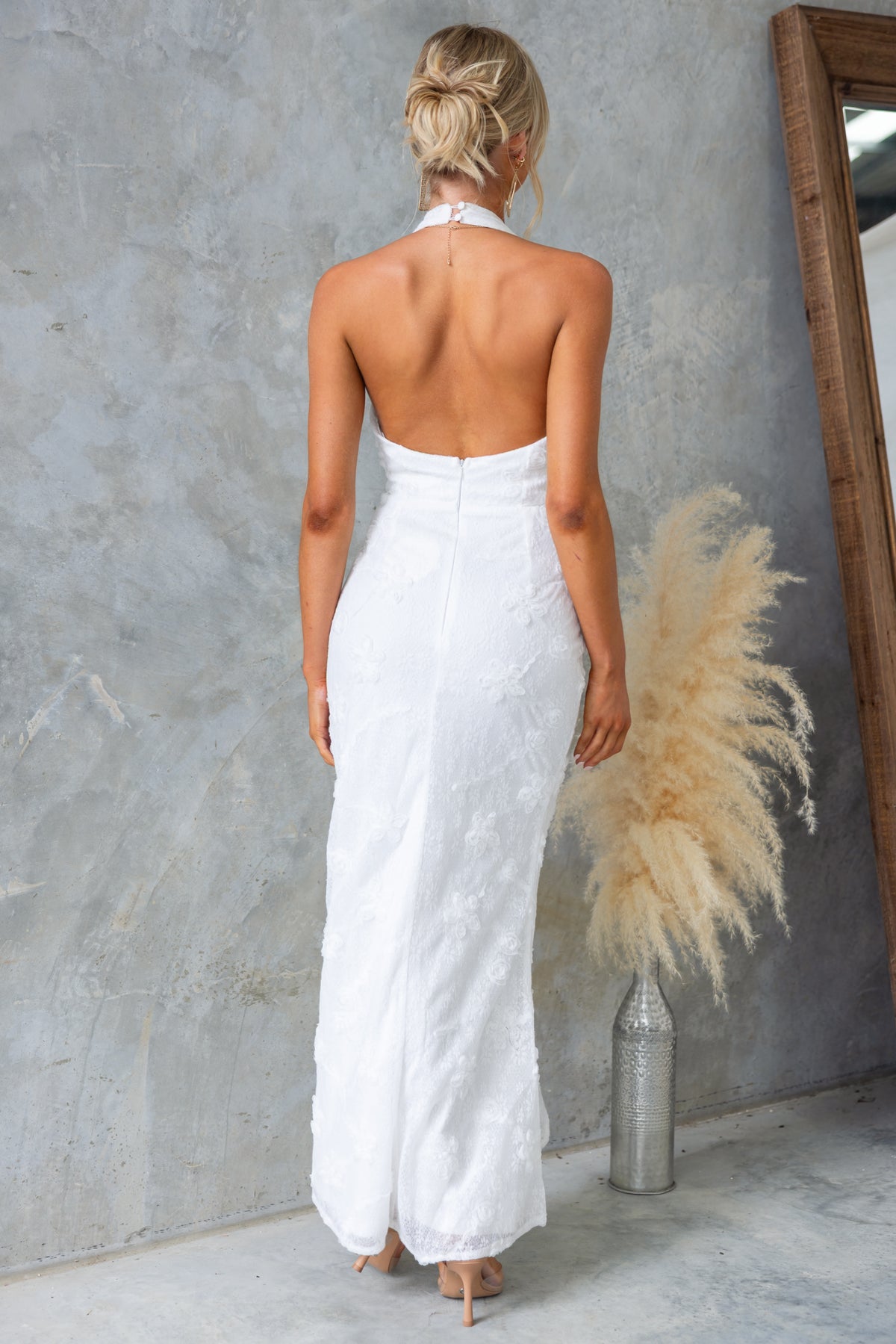 Back view of the Metrick Maxi Dress featuring a halter V-neckline and fishtail hem, designed for a standard fit.