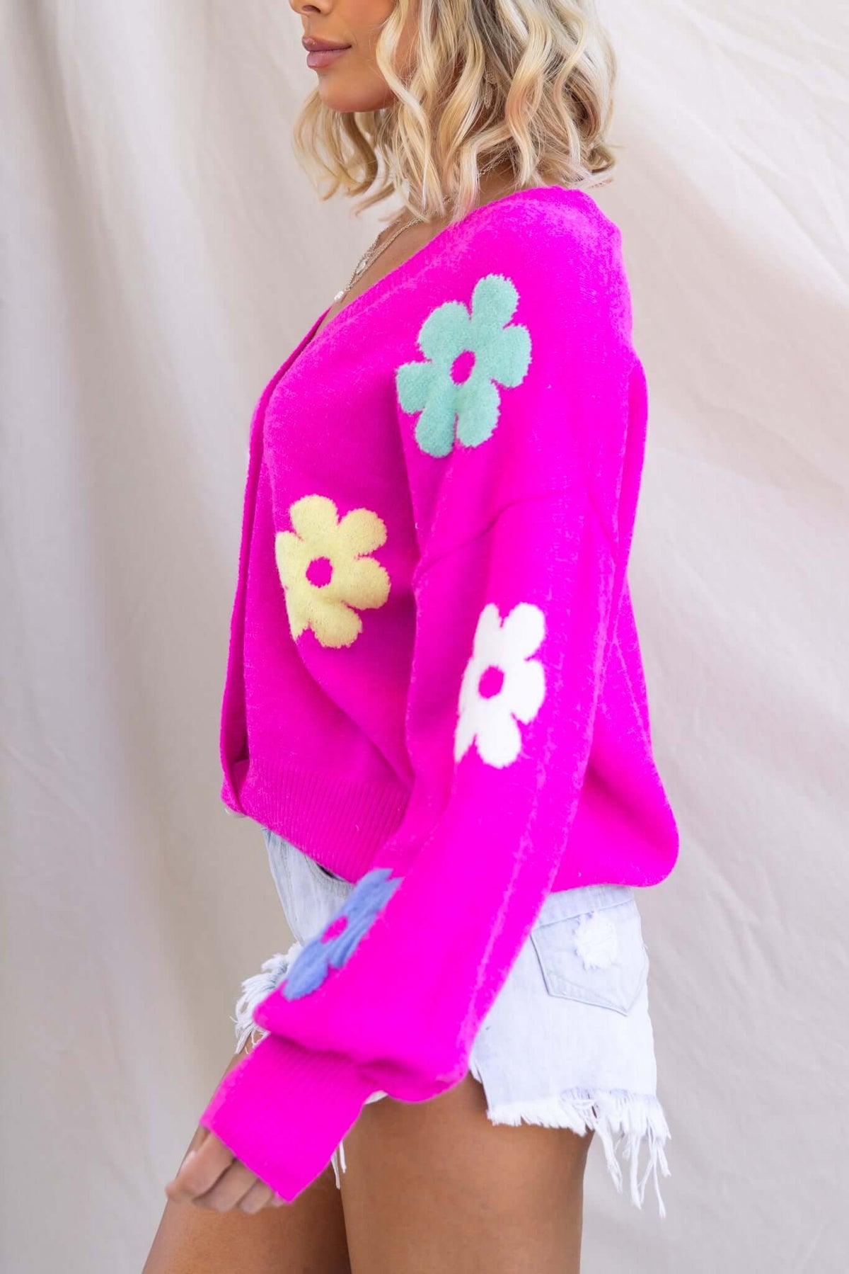 Mimsie Cardigan featuring V-neckline, button-up front, and colorful flower designs on a pink knit fabric.