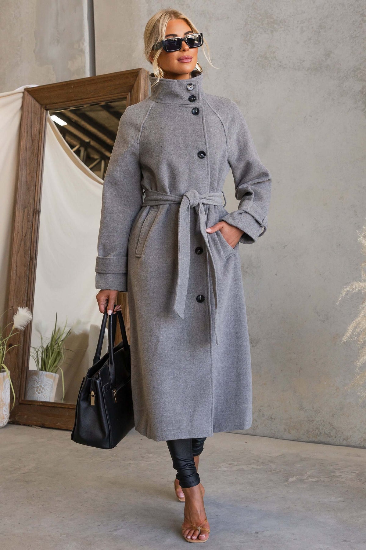 Model wearing the Modern Love Coat with funnel neck and removable belt, accessorized for a chic look.