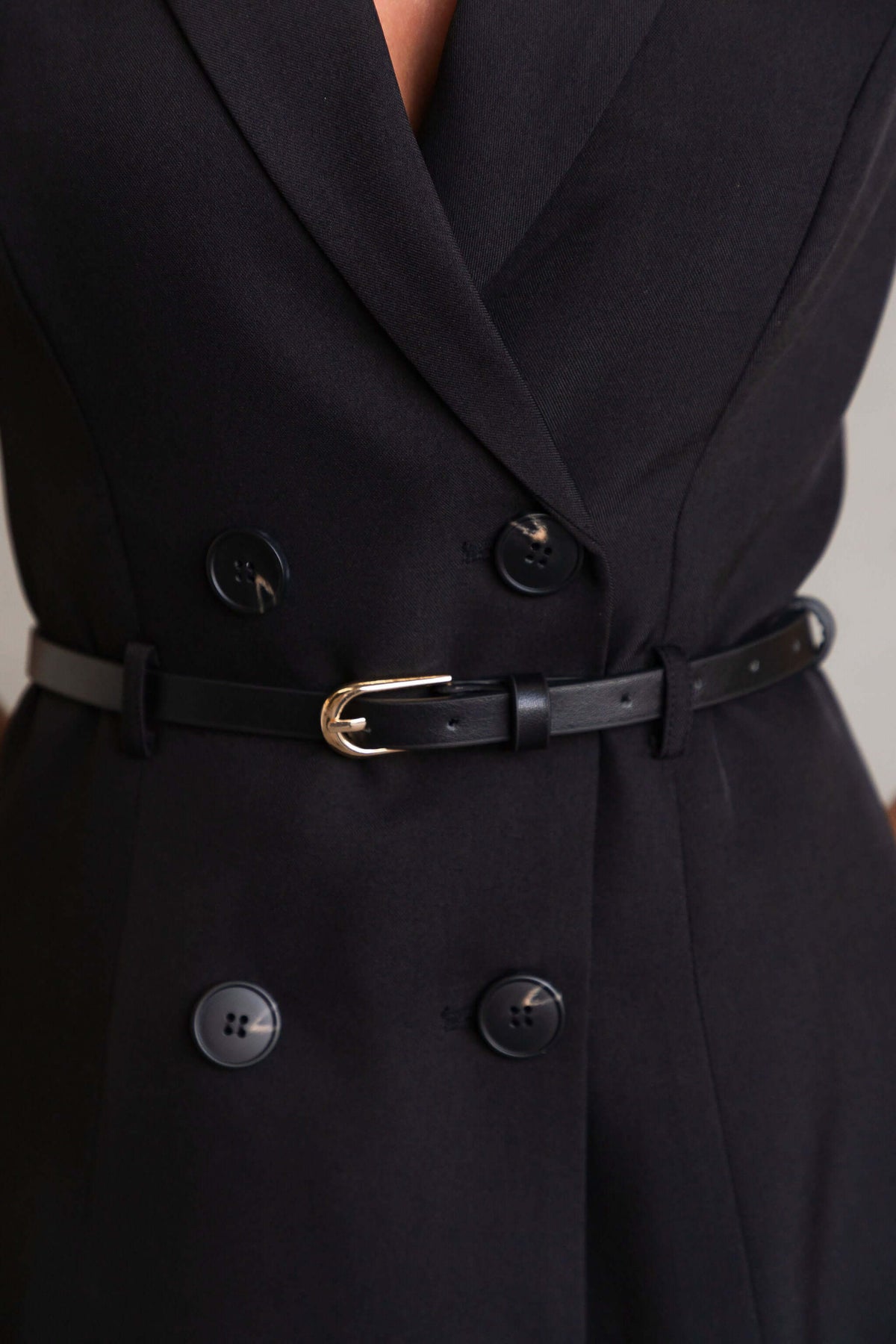 Close-up of the Moko Dress featuring a V-neckline and a black button-up front with a removable belt.