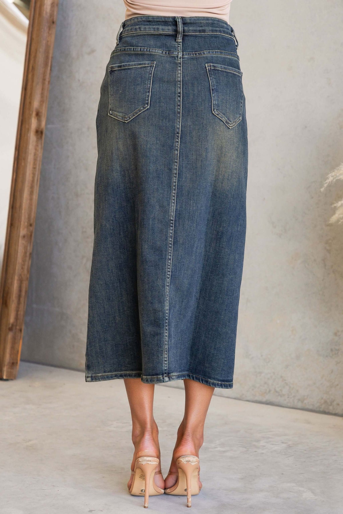 Back view of the Moon Denim Midi Skirt showcasing the mid-high waist, split design, and pockets.