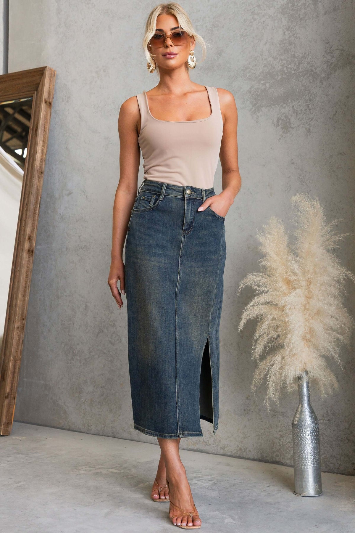 Model wearing a stylish Moon Denim Midi Skirt with split, paired with a beige top and accessories.
