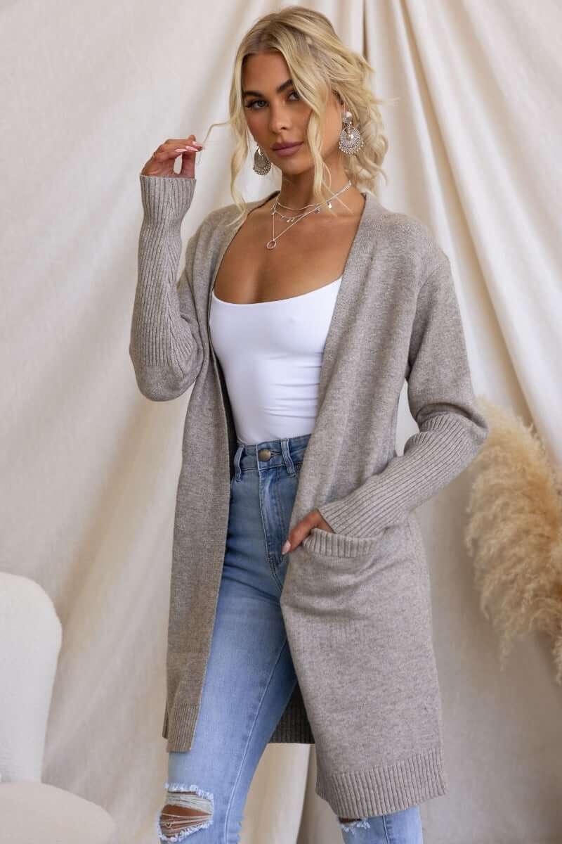 Model wearing a longline ribbed knit Motherly Cardigan in light gray, styled with skinny jeans and a simple white top.