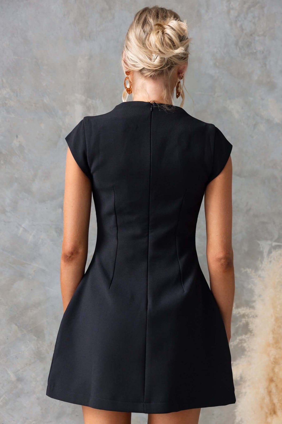 Back view of the Natick Dress featuring a high neckline, invisible zip, faux pockets, and a fitted design.