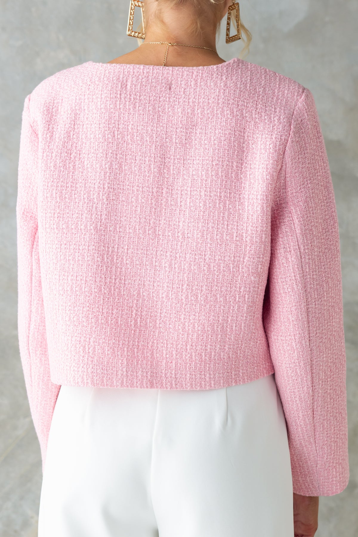 Back view of Noelle Jacket in pink chenille fabric, showcasing button-up details and shoulder pads.