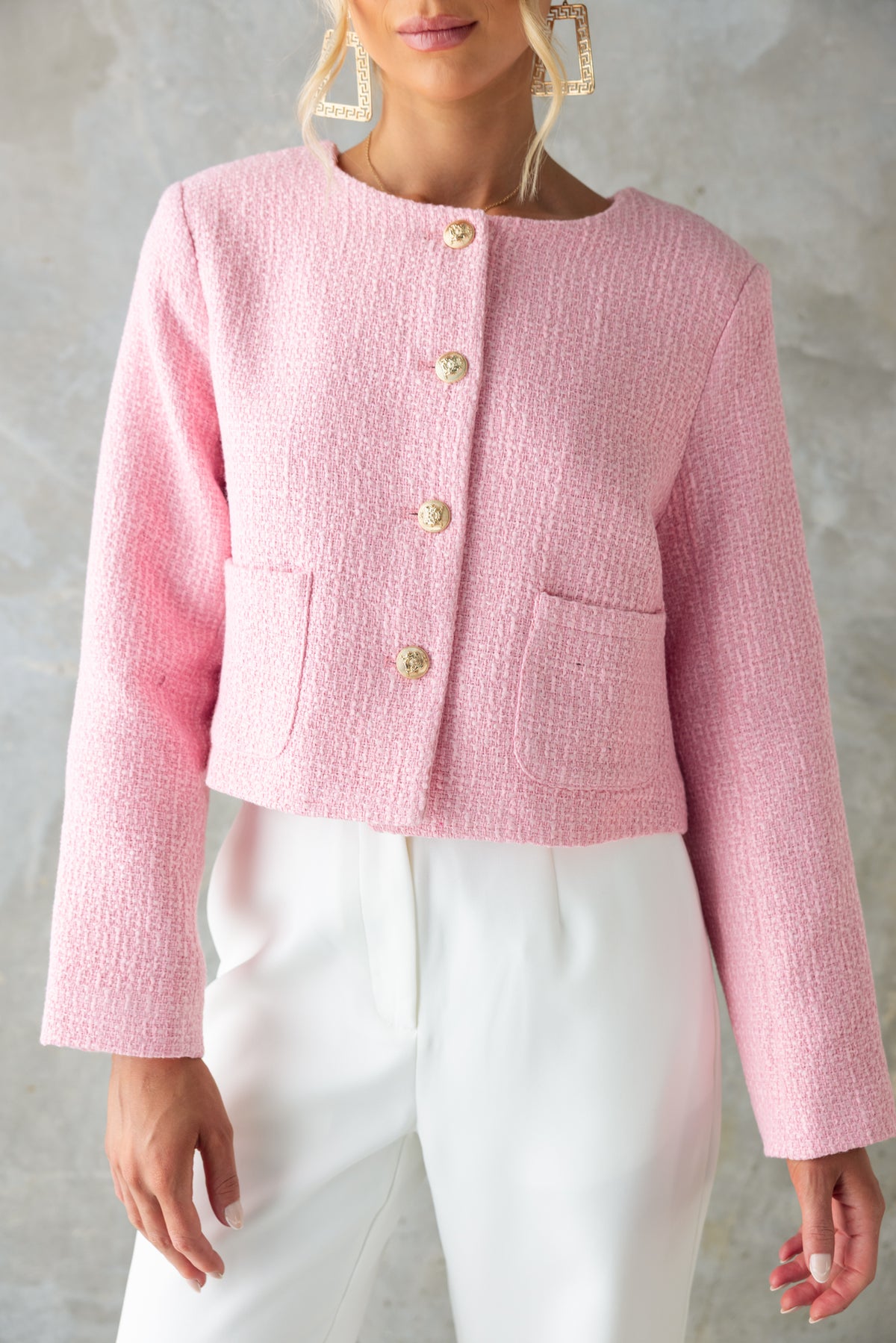Noelle Jacket in pink chenille fabric with button-up front and pockets, styled with white pants for a chic look.