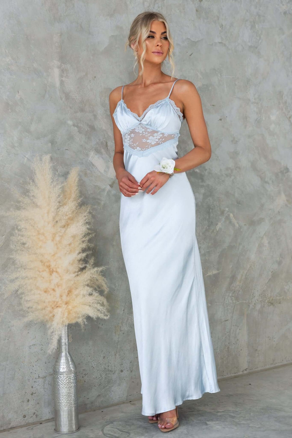 Stylish woman in a light blue Obsidian Maxi Dress with lace panel and adjustable straps, posing elegantly.