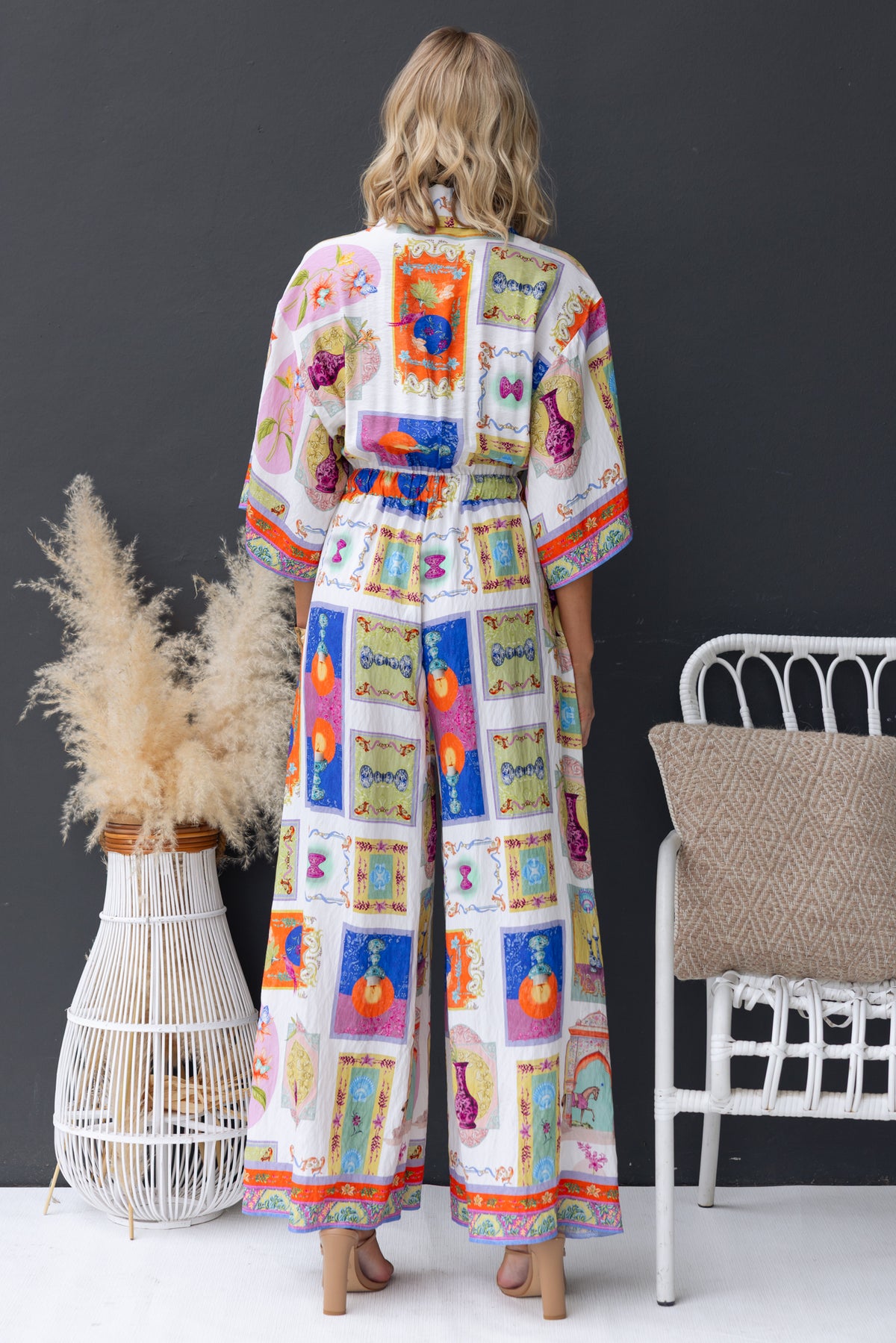 Back view of the colorful Perrin Jumpsuit featuring a collar, button-up front, and elastic waistband with pockets.