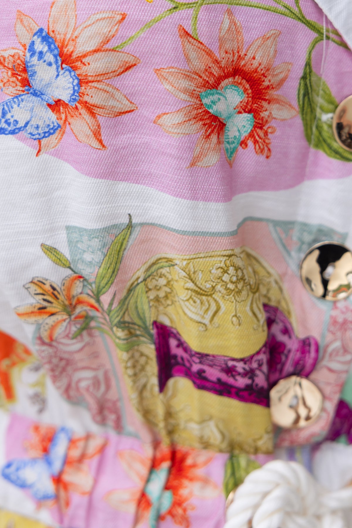 Colorful floral print on Perrin jumpsuit featuring butterflies and decorative elements.