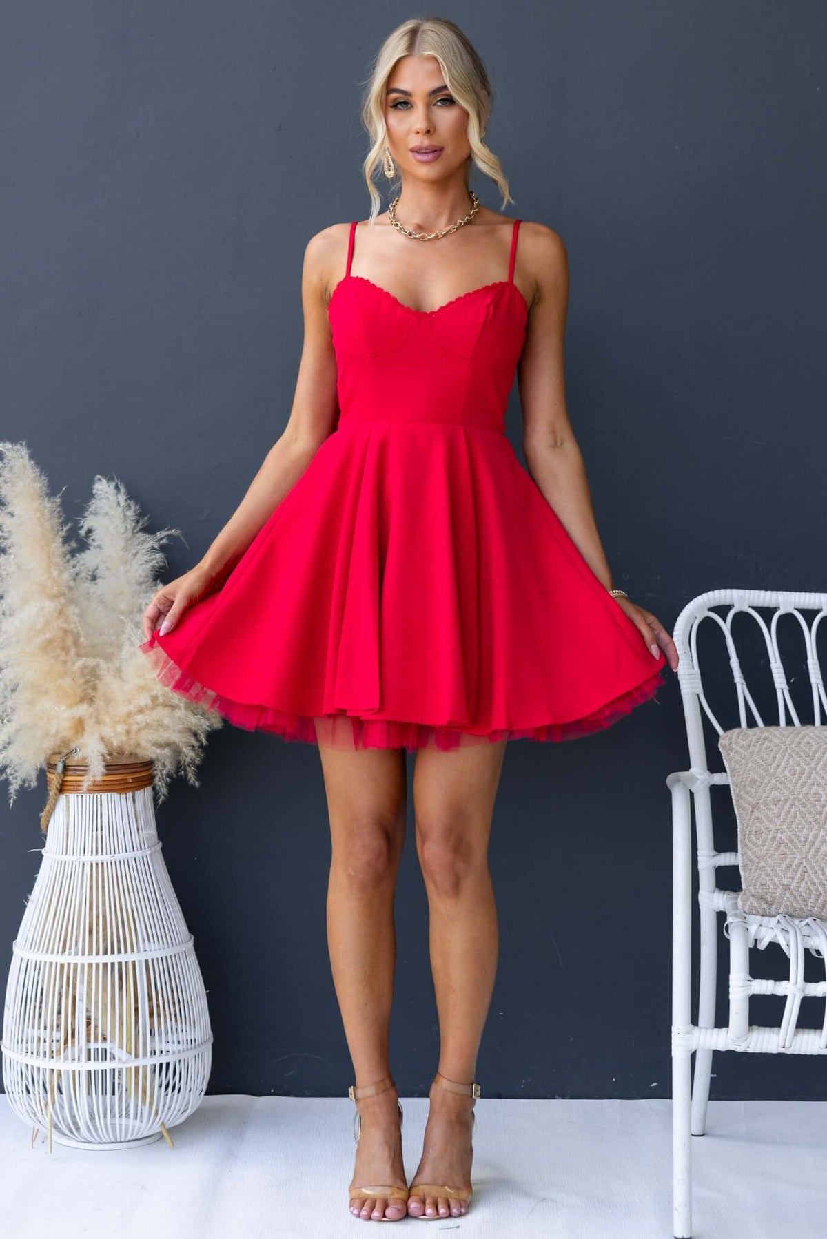 Red Pescia Dress with adjustable straps, tulle underlay, and an invisible zip, styled for a summer look.