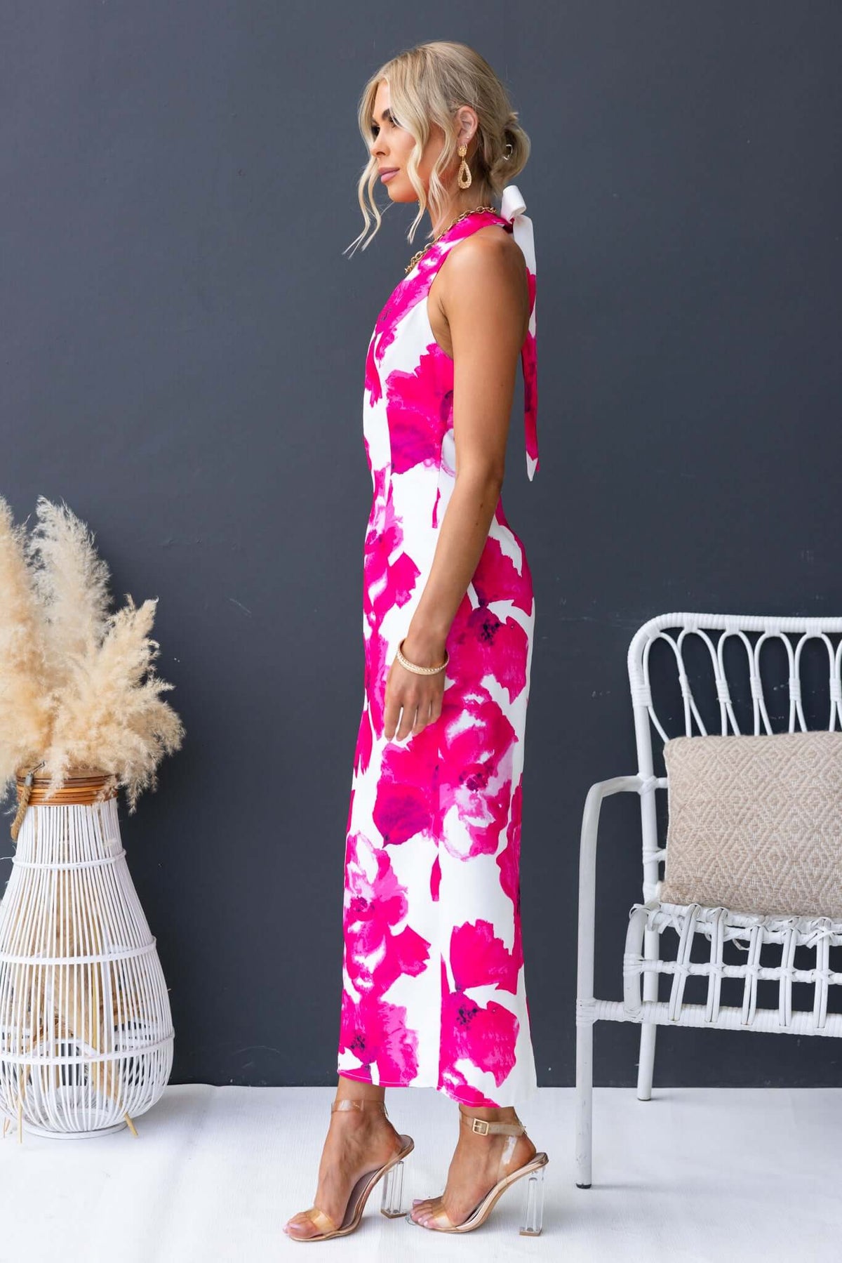 Model wearing the Pianni Maxi Dress featuring a tie halter neckline and vibrant pink floral print.