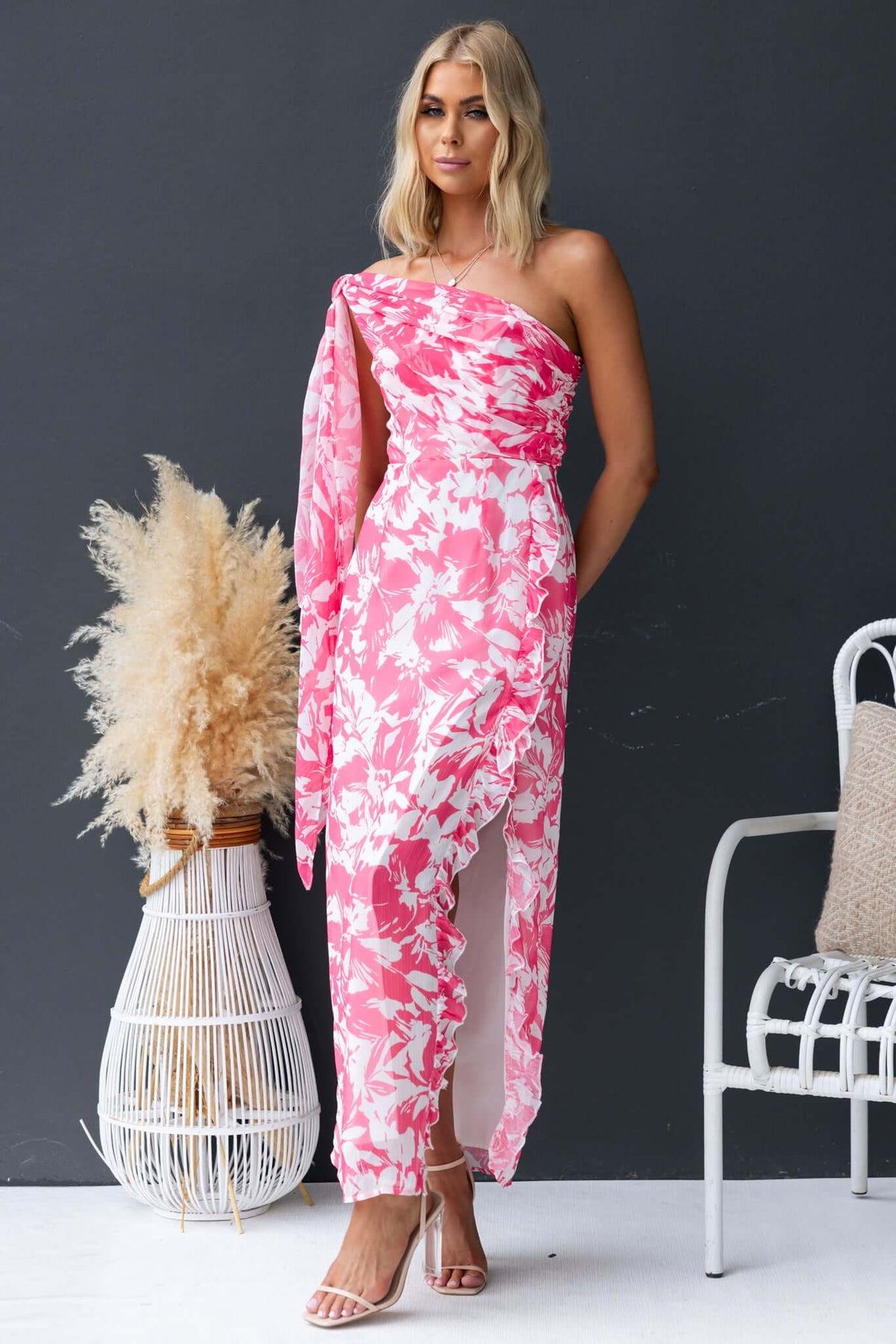 Model wearing the Nurture Maxi Dress in pink floral print with a strapless design and side split.