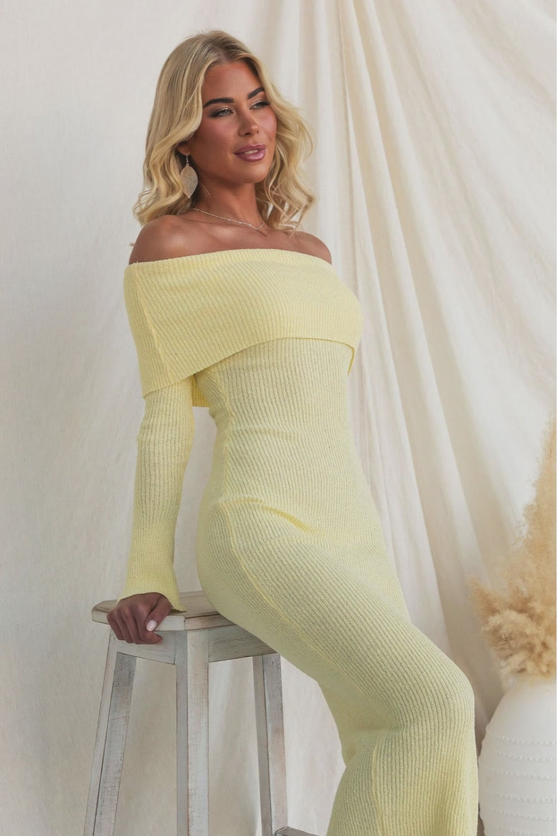 Model wearing the Breeze Midi Dress in soft yellow with an off-shoulder neckline, ribbed knit material.