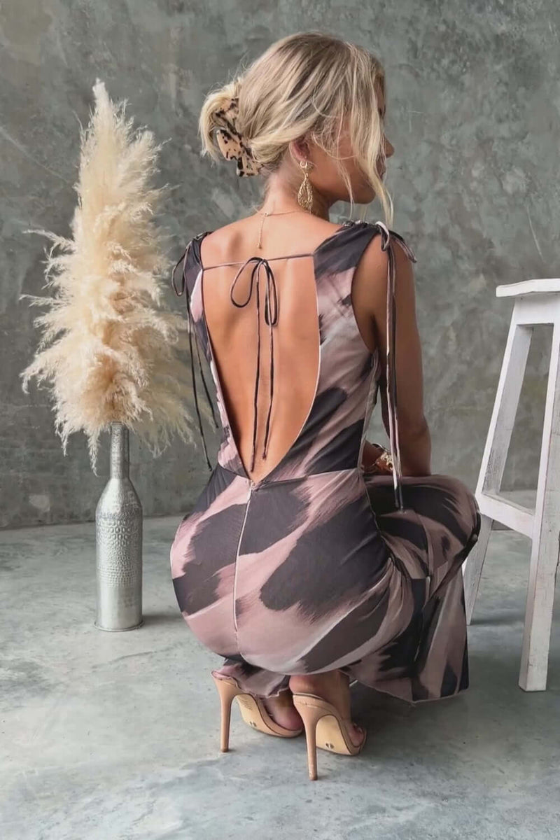 Back view of a woman in a Verone Maxi Dress with a cowl neckline and tie details, showcasing a low-cut back.